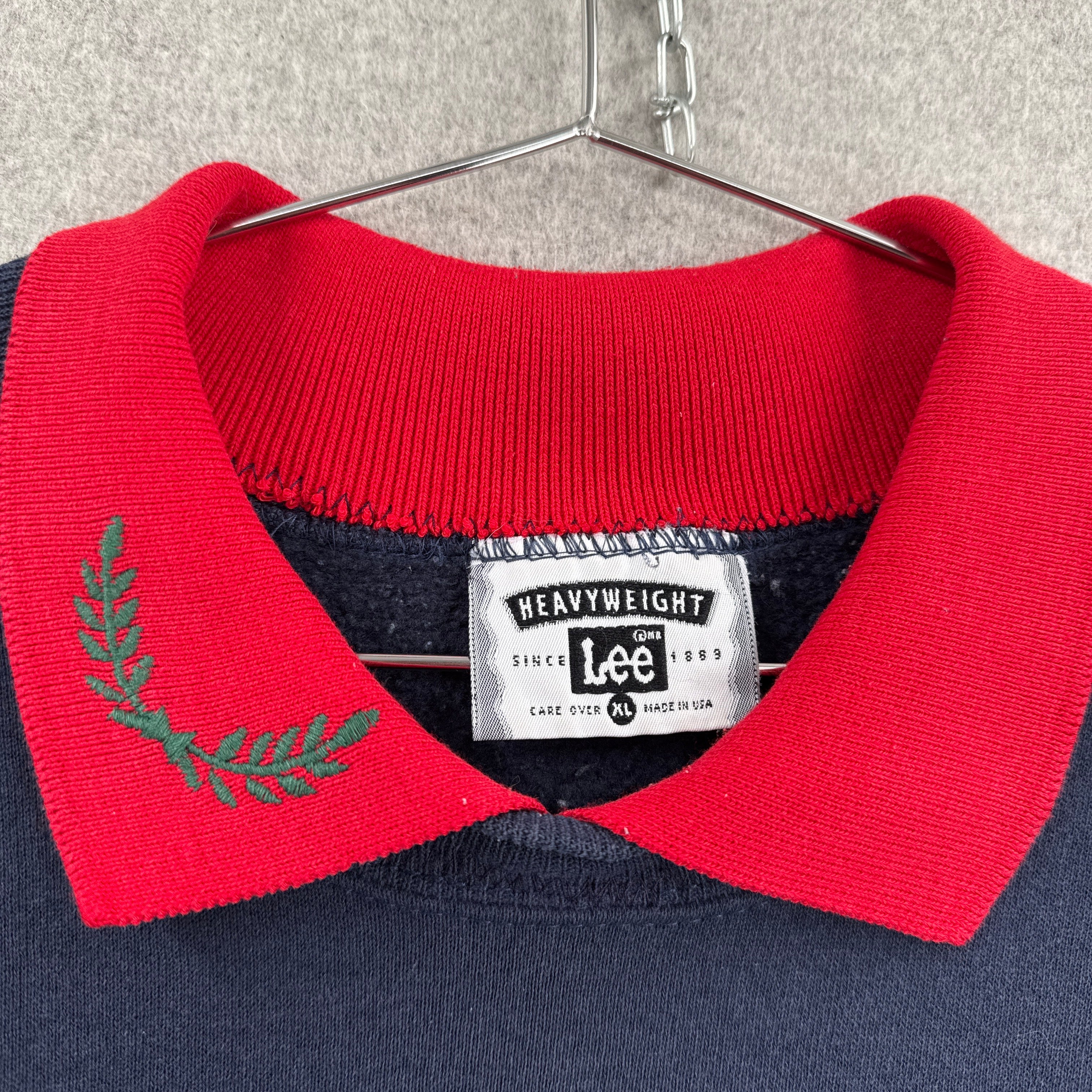 Close-up of a red and navy sweater with a Lee label on a gray surface. size XL made in USA
