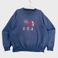 Blue sweatshirt with USA flag design on a textured surface