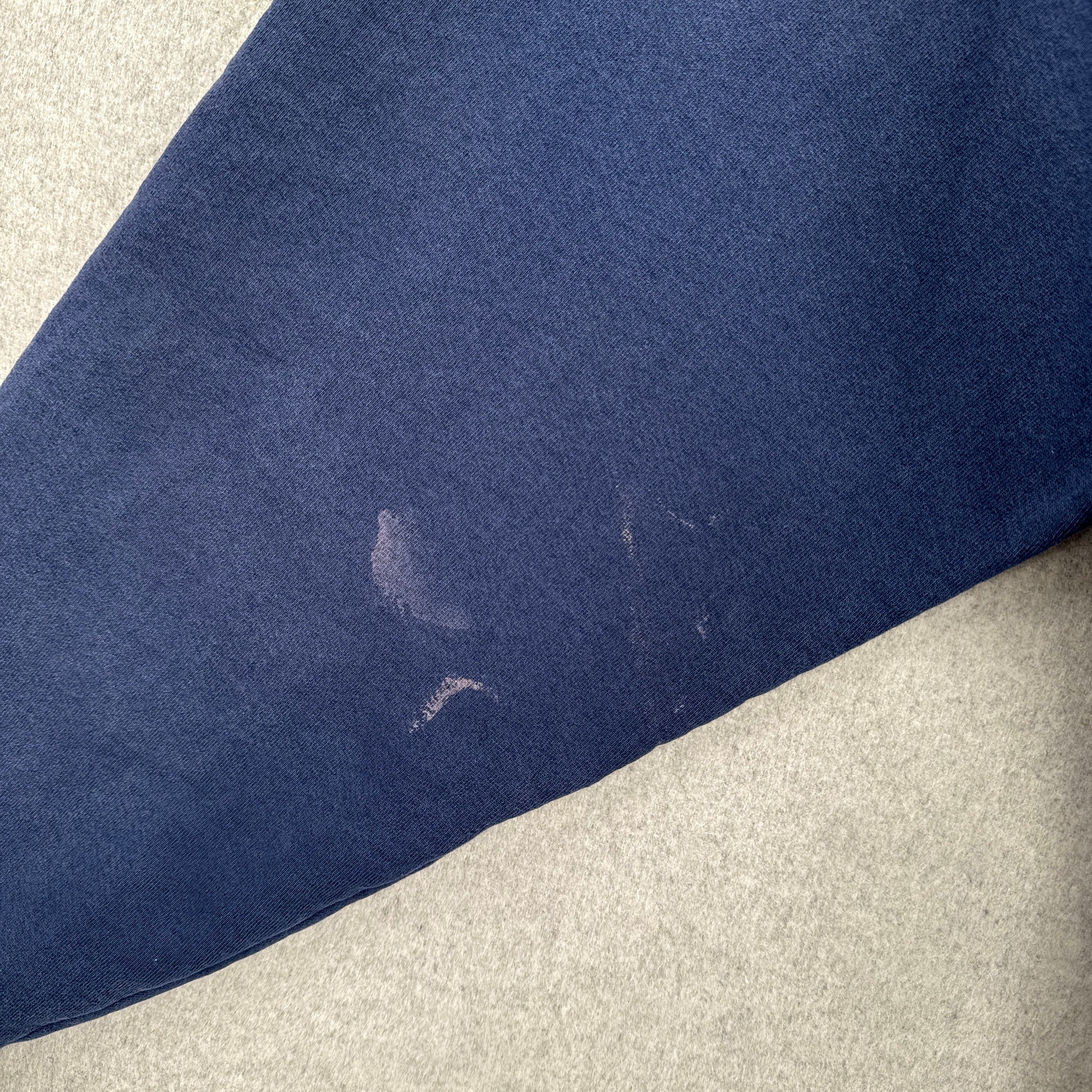 Navy blue fabric with a small stain on a light gray surface