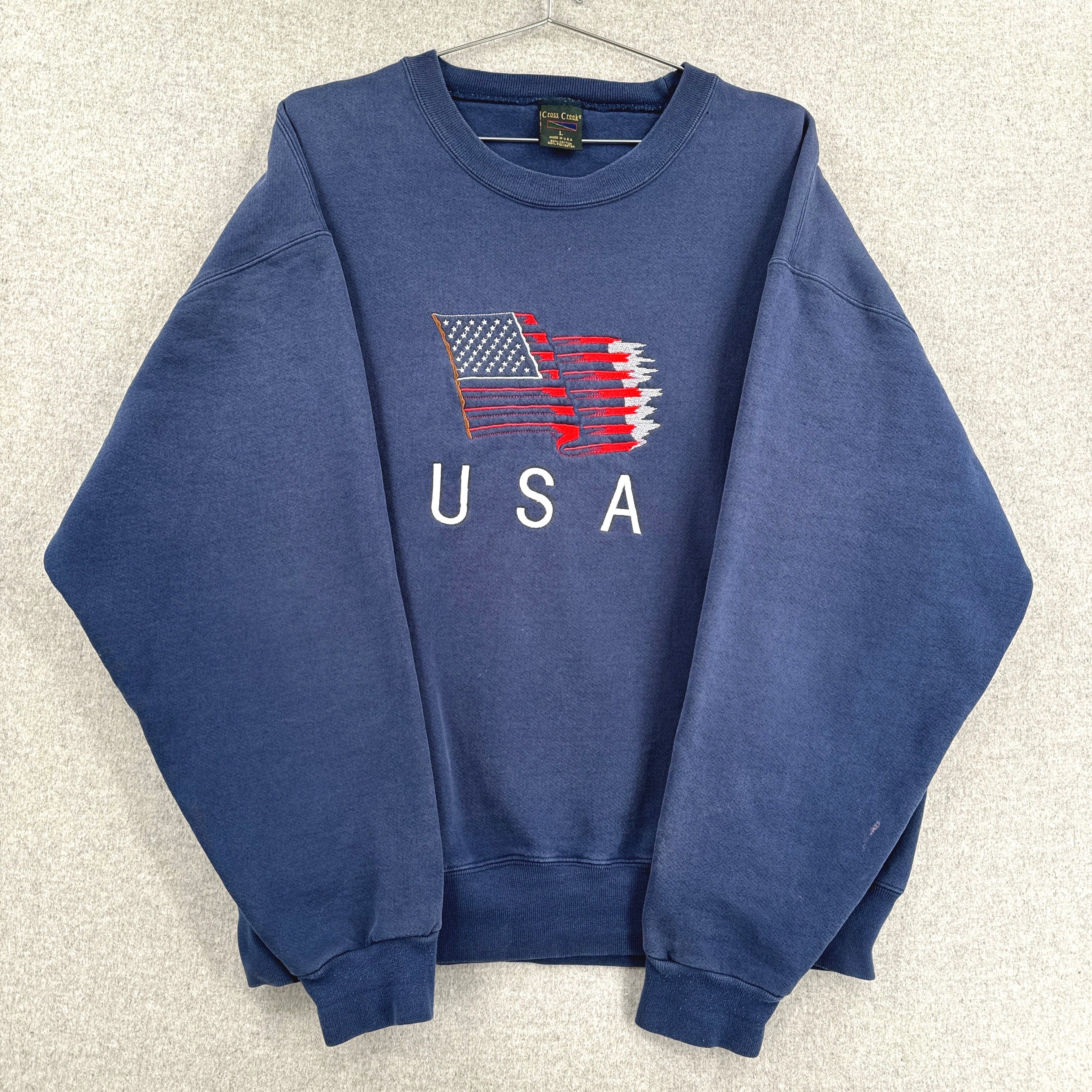 Blue sweatshirt with American flag and 'USA' text on a light gray background