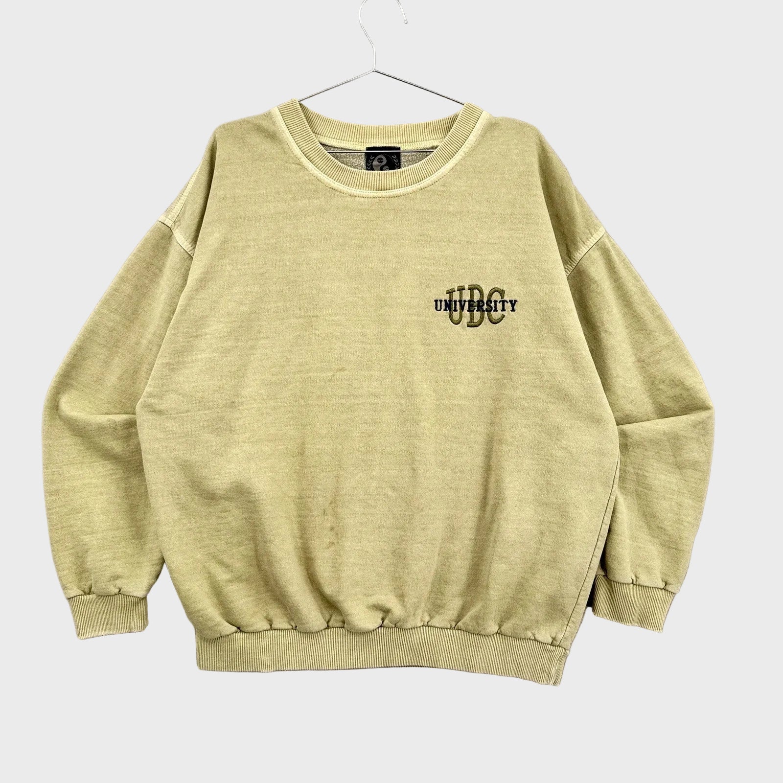 Light yellowish green sweatshirt with 'UBC' logo on a gray background