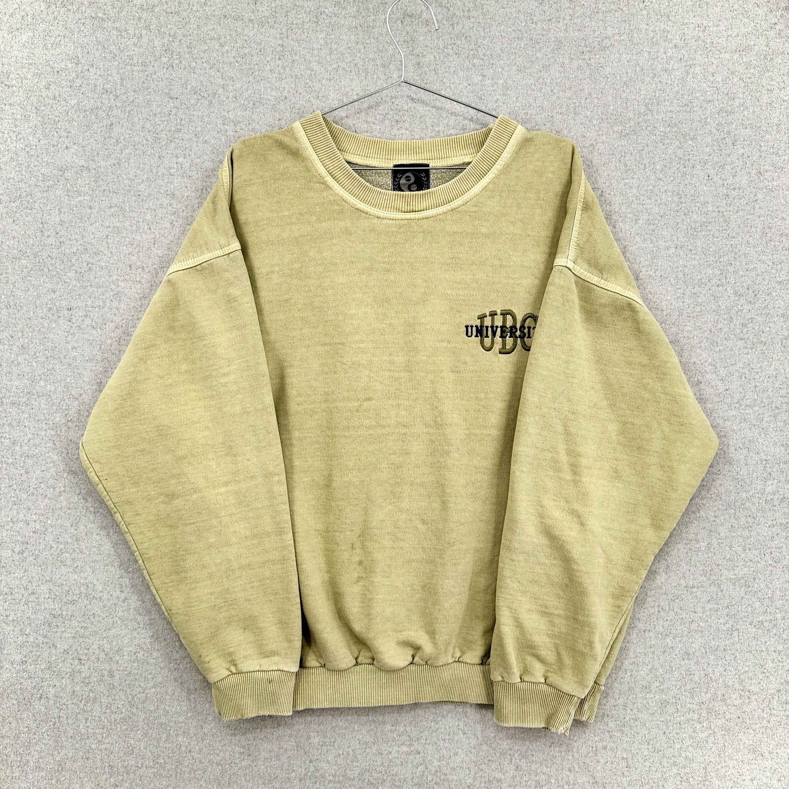 Beige sweatshirt with a logo on a gray background