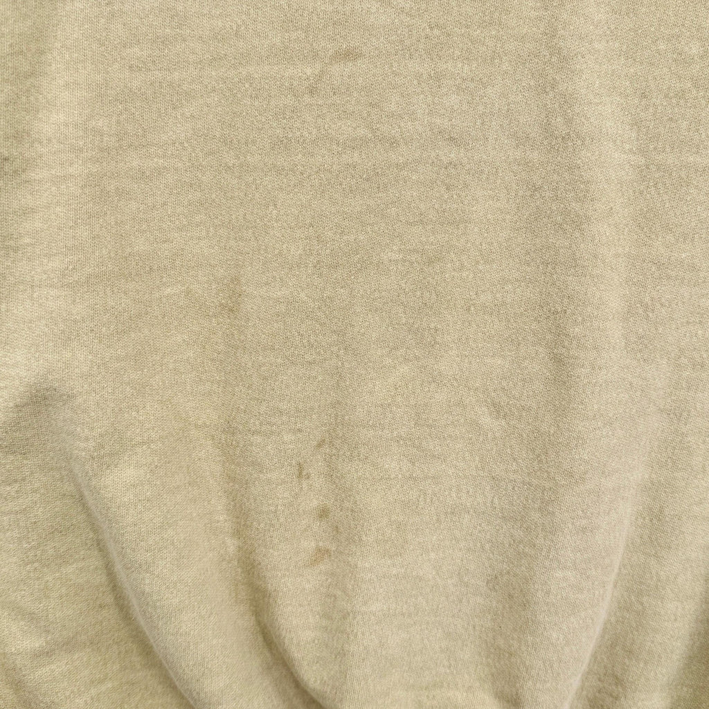 Close-up of yellow beige fabric with visible texture and stain spots
