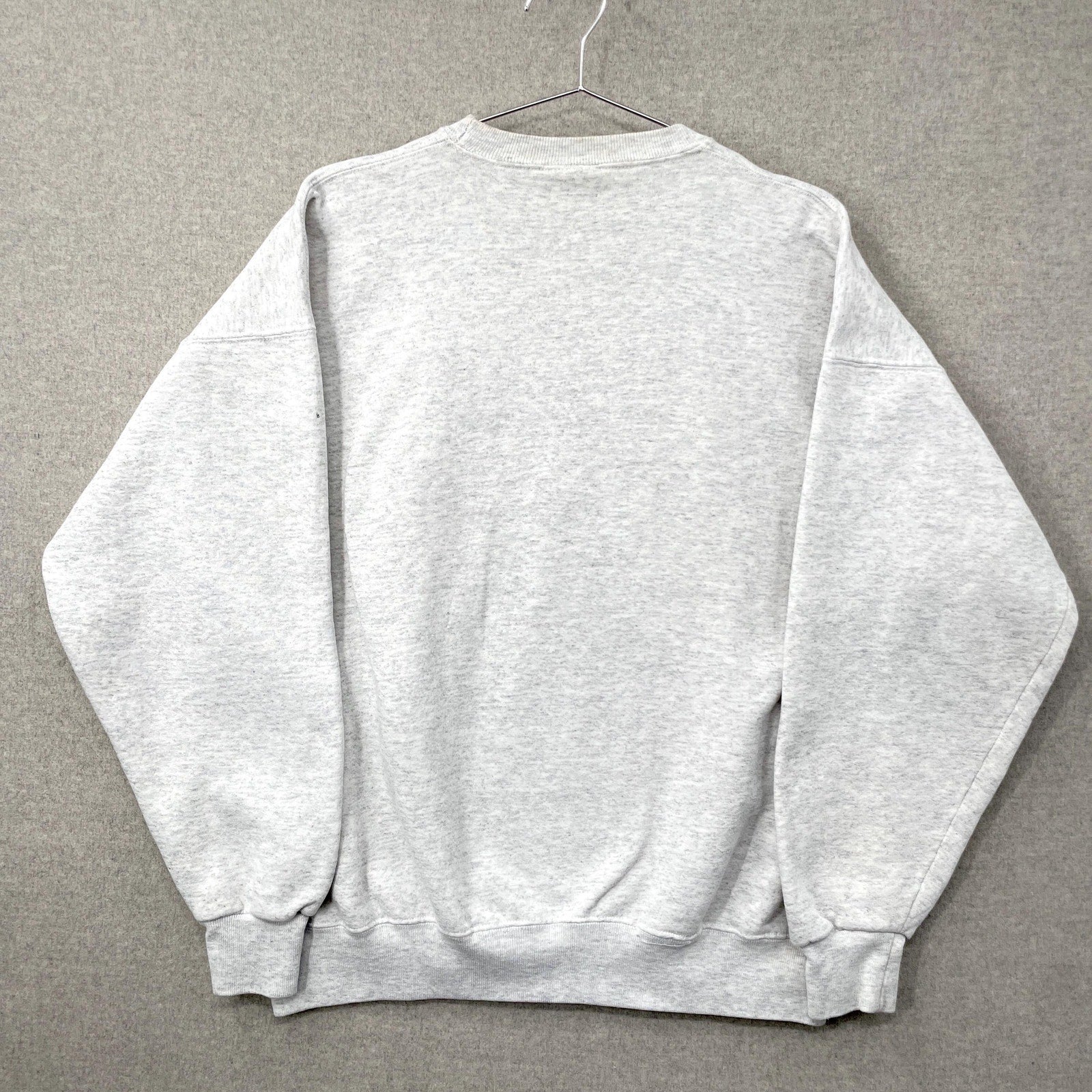Gray sweatshirt on a hanger against a gray background