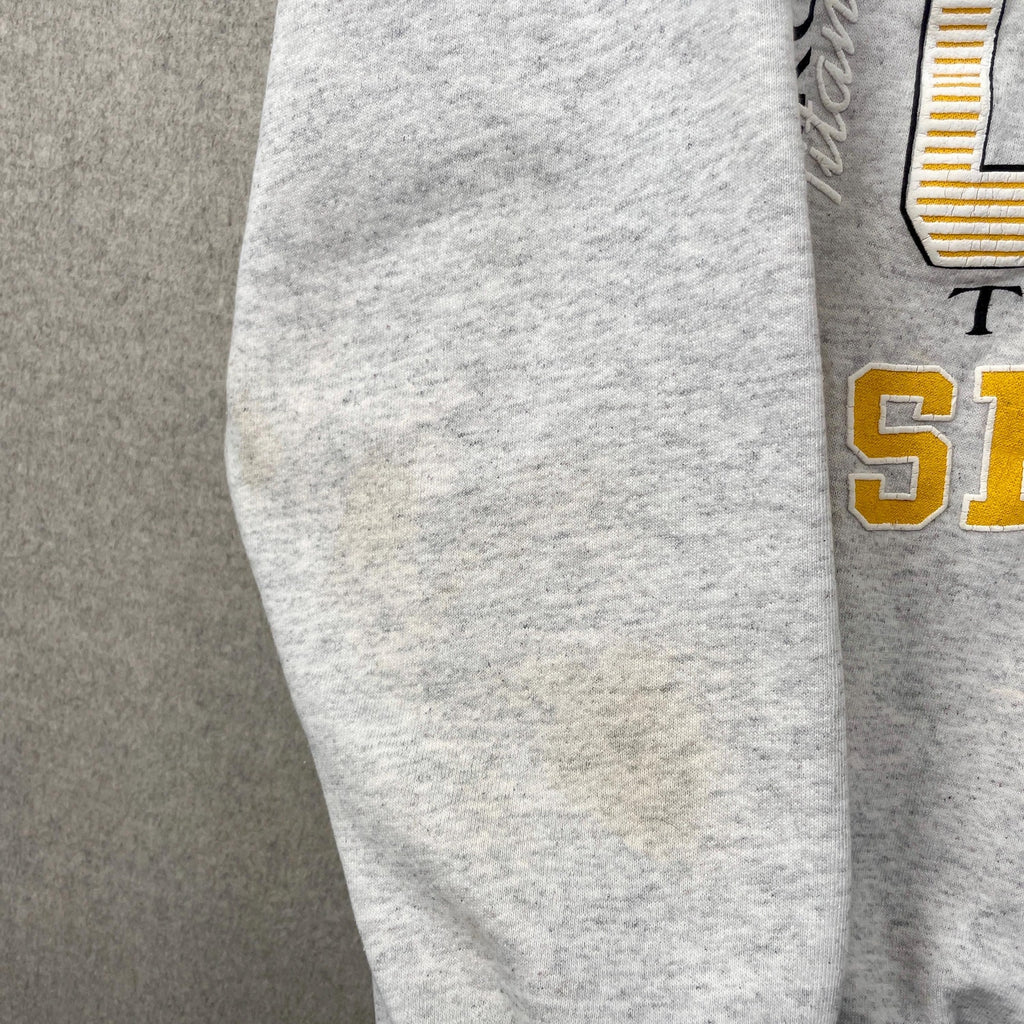 Gray sweatpants with gold and black text on a gray background