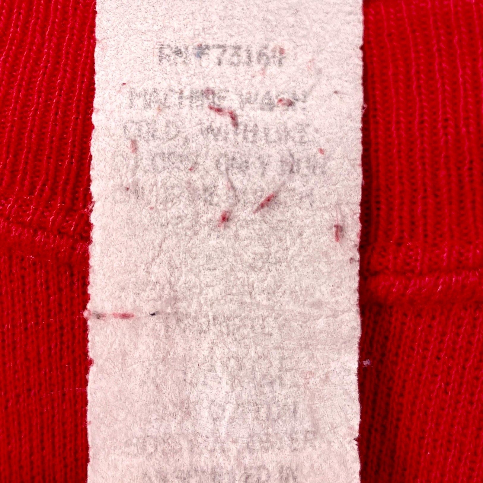 Close-up of a red fabric with a white label displaying text.