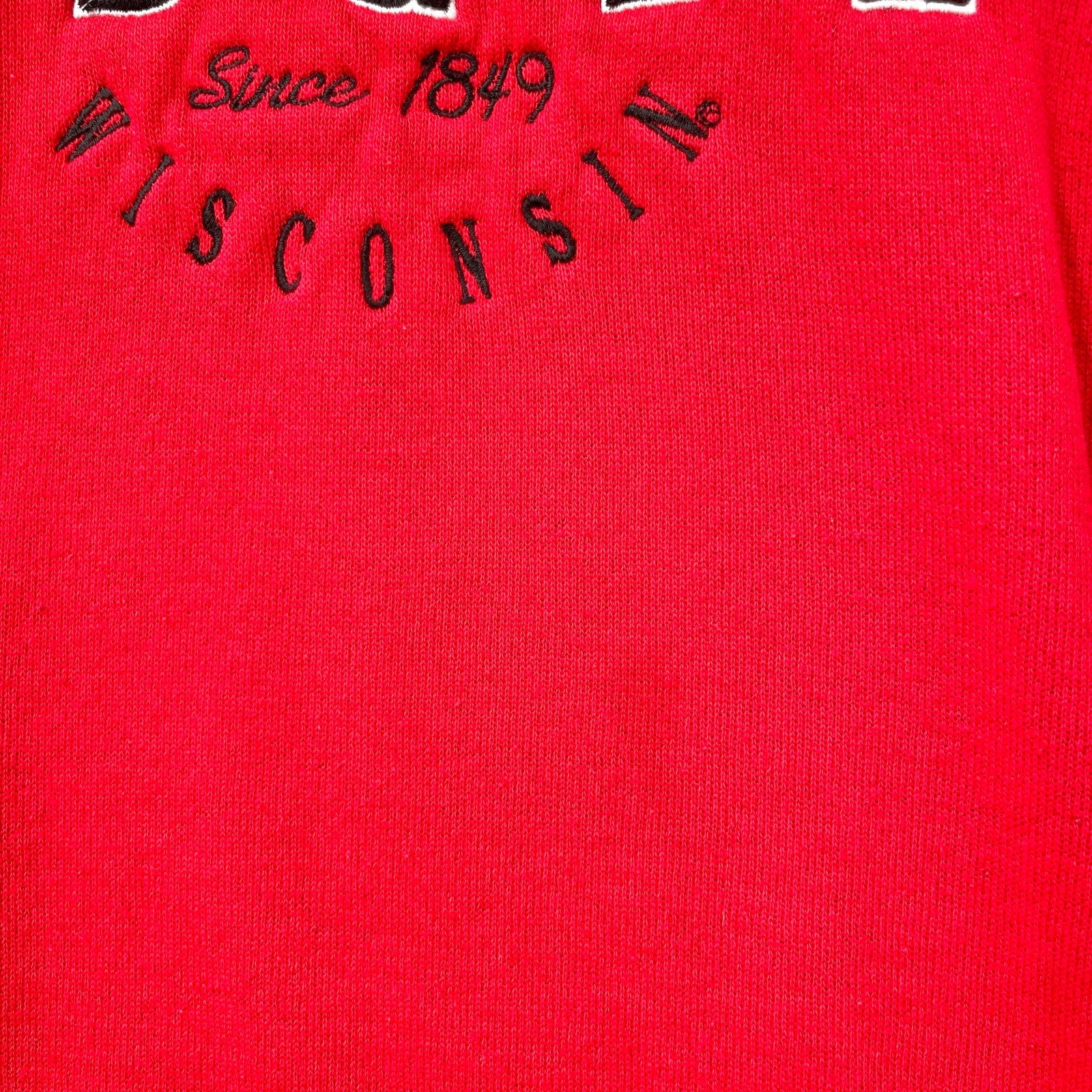 Red fabric with 'WISCONSIN' and 'Since 1849' text embroidered on it