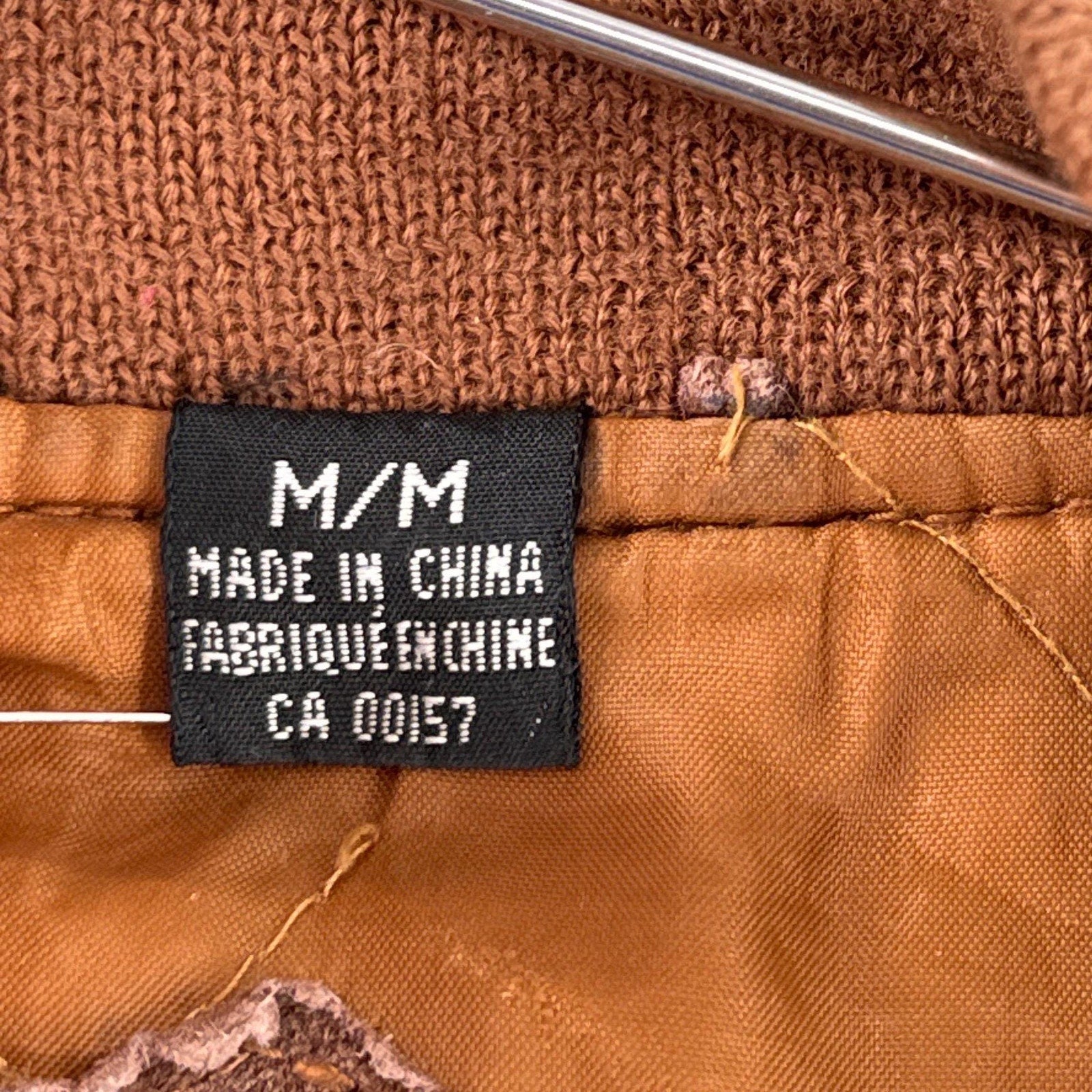 Close-up of a brown fabric with a 'Made in China' label. size Medium