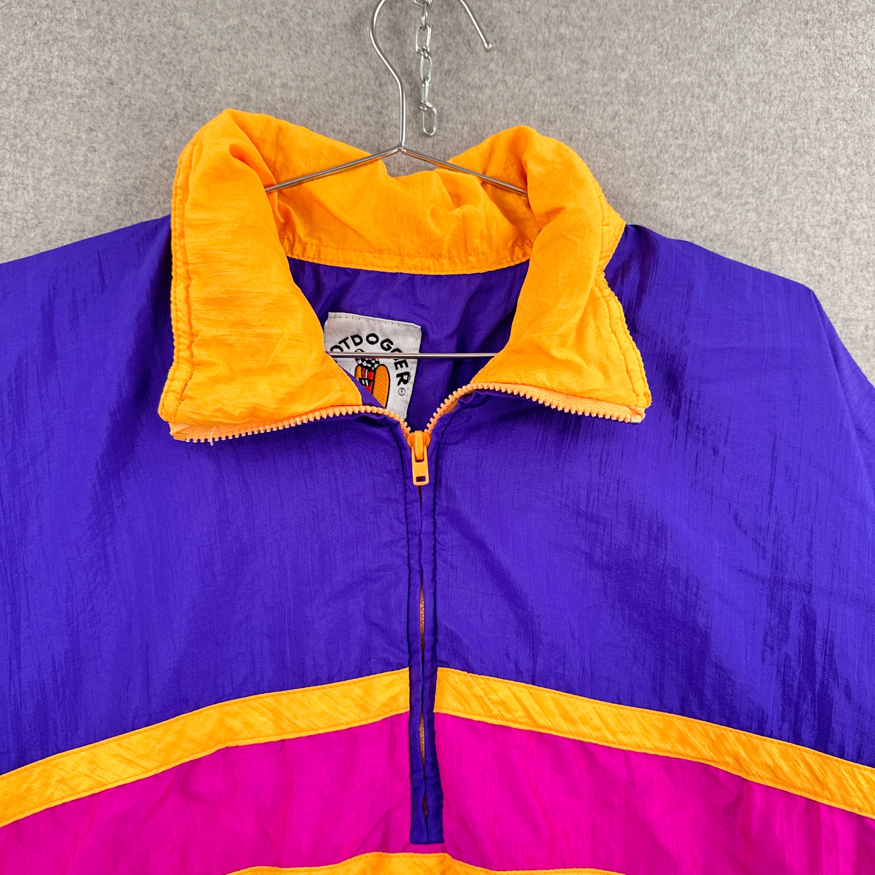 Colorful jacket with yellow and purple accents on a hanger against a gray background