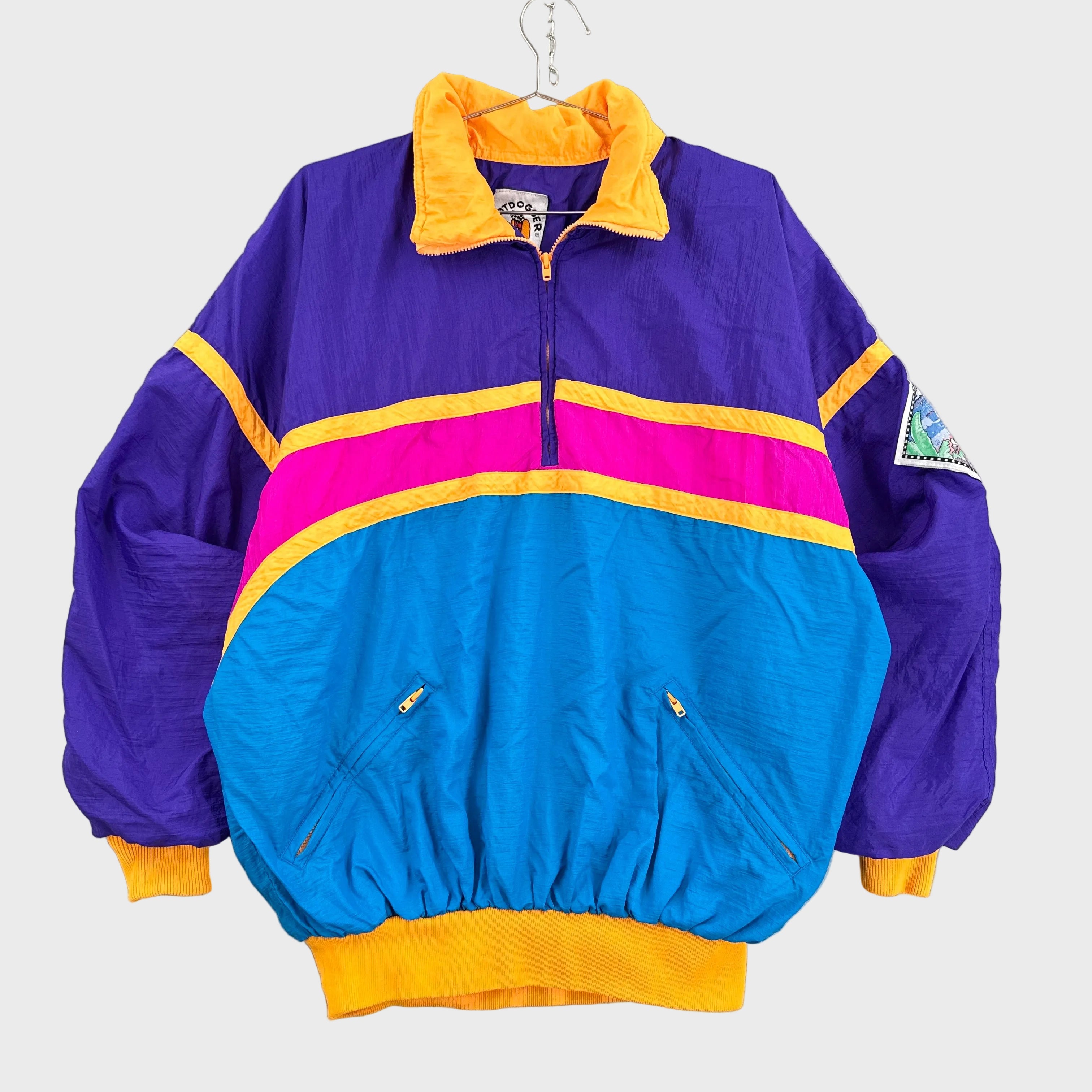 Multicolored jacket with purple, blue, pink, and yellow accents on a gray background