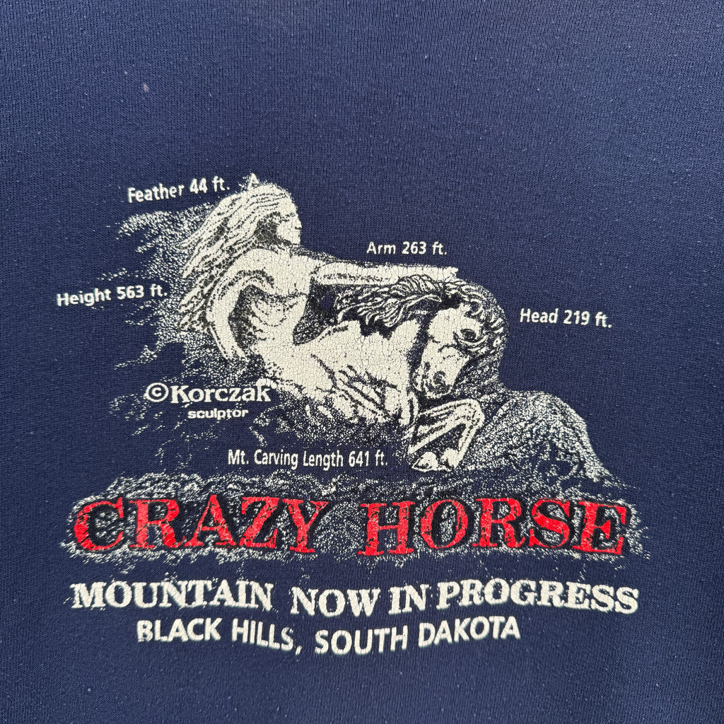 Navy blue sweatshirt with white and red text and graphics about the Crazy Horse Memorial.