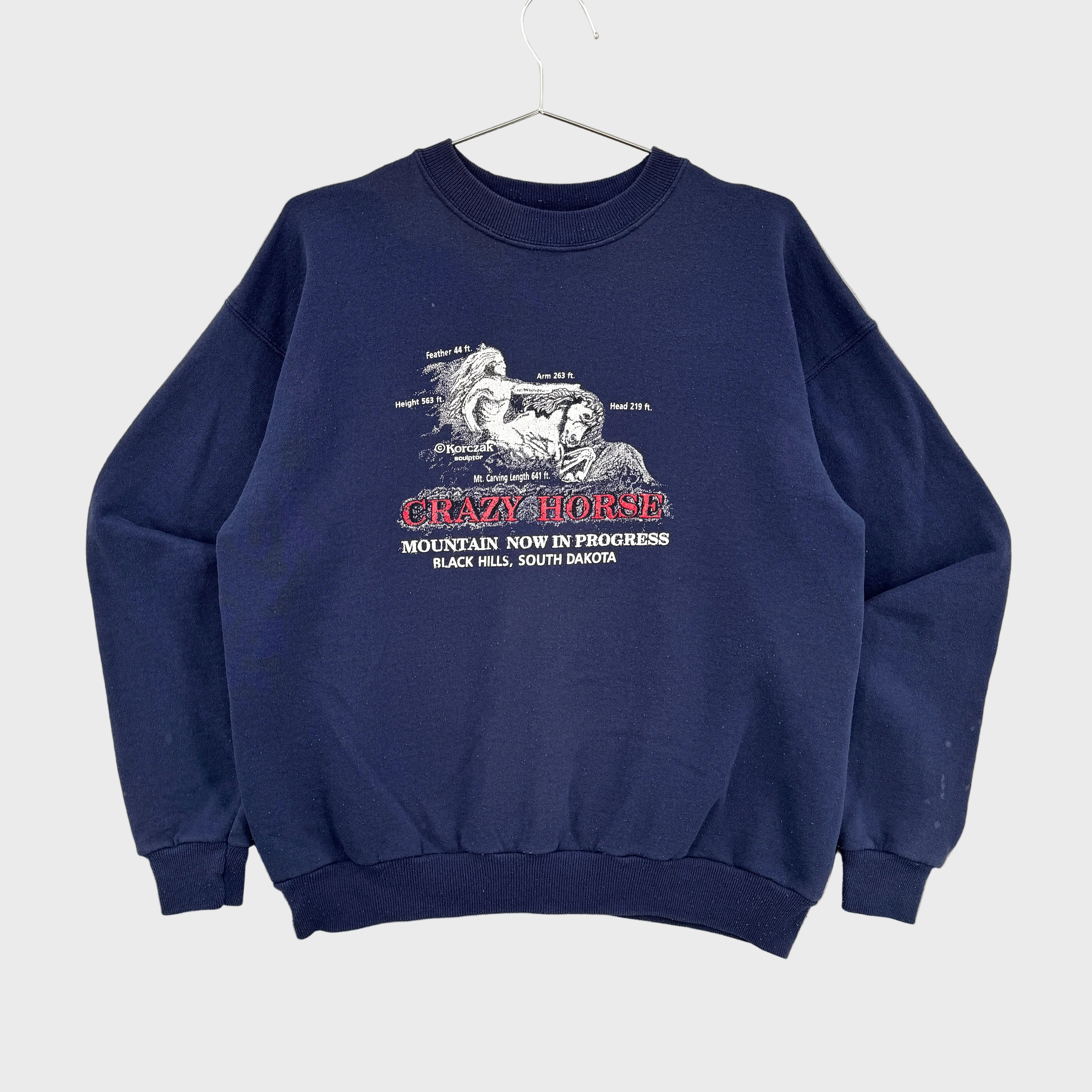Navy blue sweatshirt with 'Crazy Horse' graphic on a beige background. Black Hills South Dakota