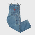 Blue jeans with a red label on a beige background. Dickies cargo pants with pockets
