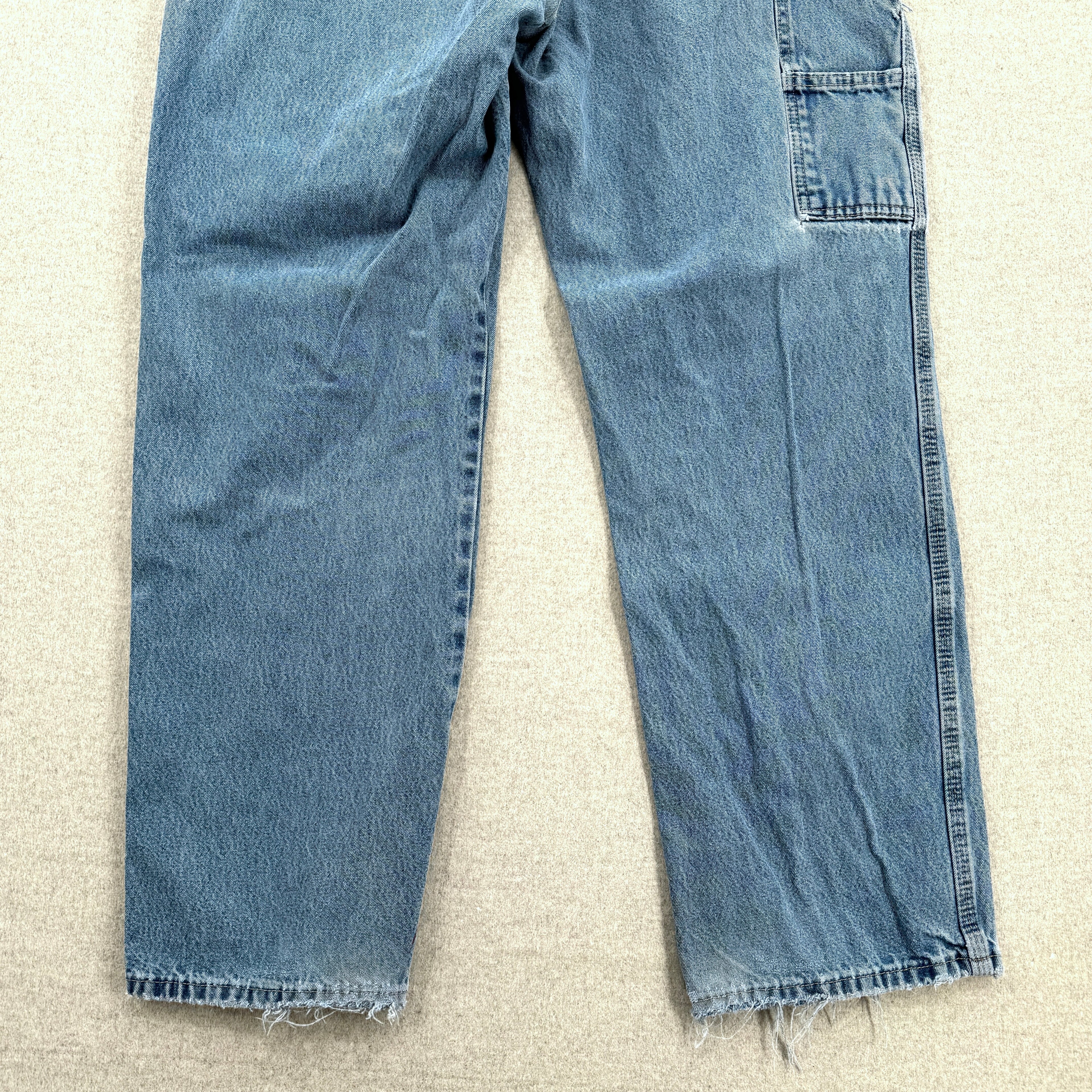 Pair of blue jeans on a beige carpet bottom back