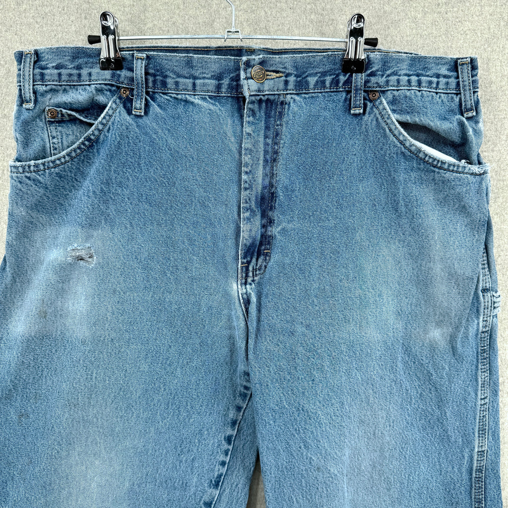 Blue jeans on a hanger against a neutral background
