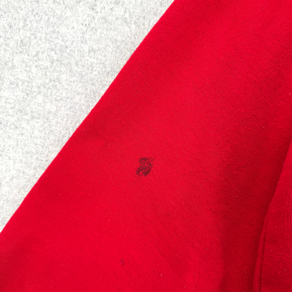 Close-up of a red fabric with a small black spot on a white background
