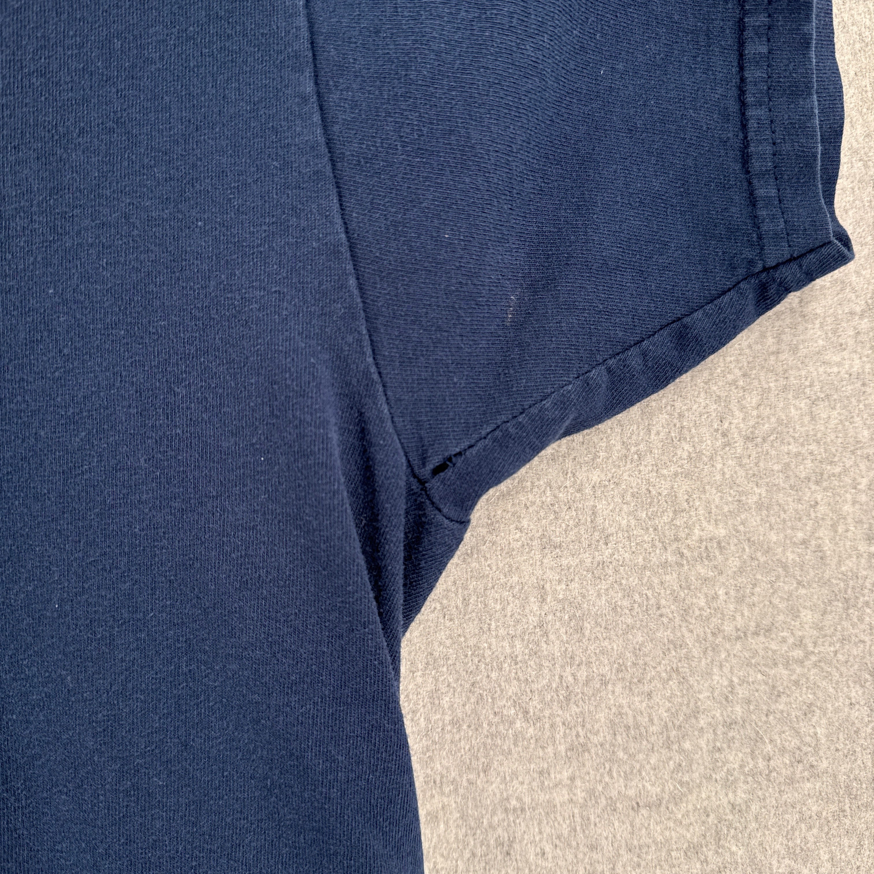 Close-up of a blue fabric with a textured background. small hole in armpit
