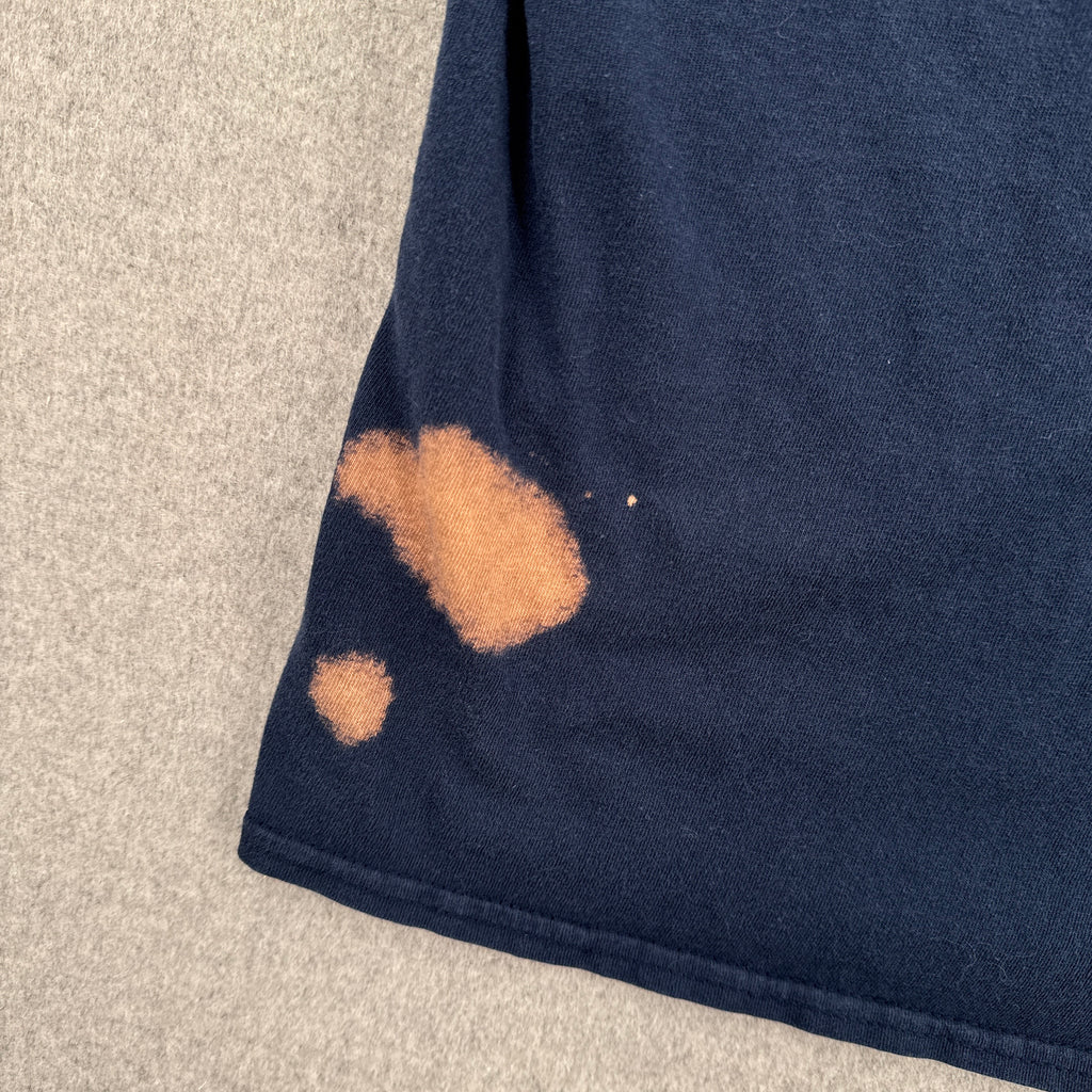 Navy fabric with a bleach stain on a gray surface