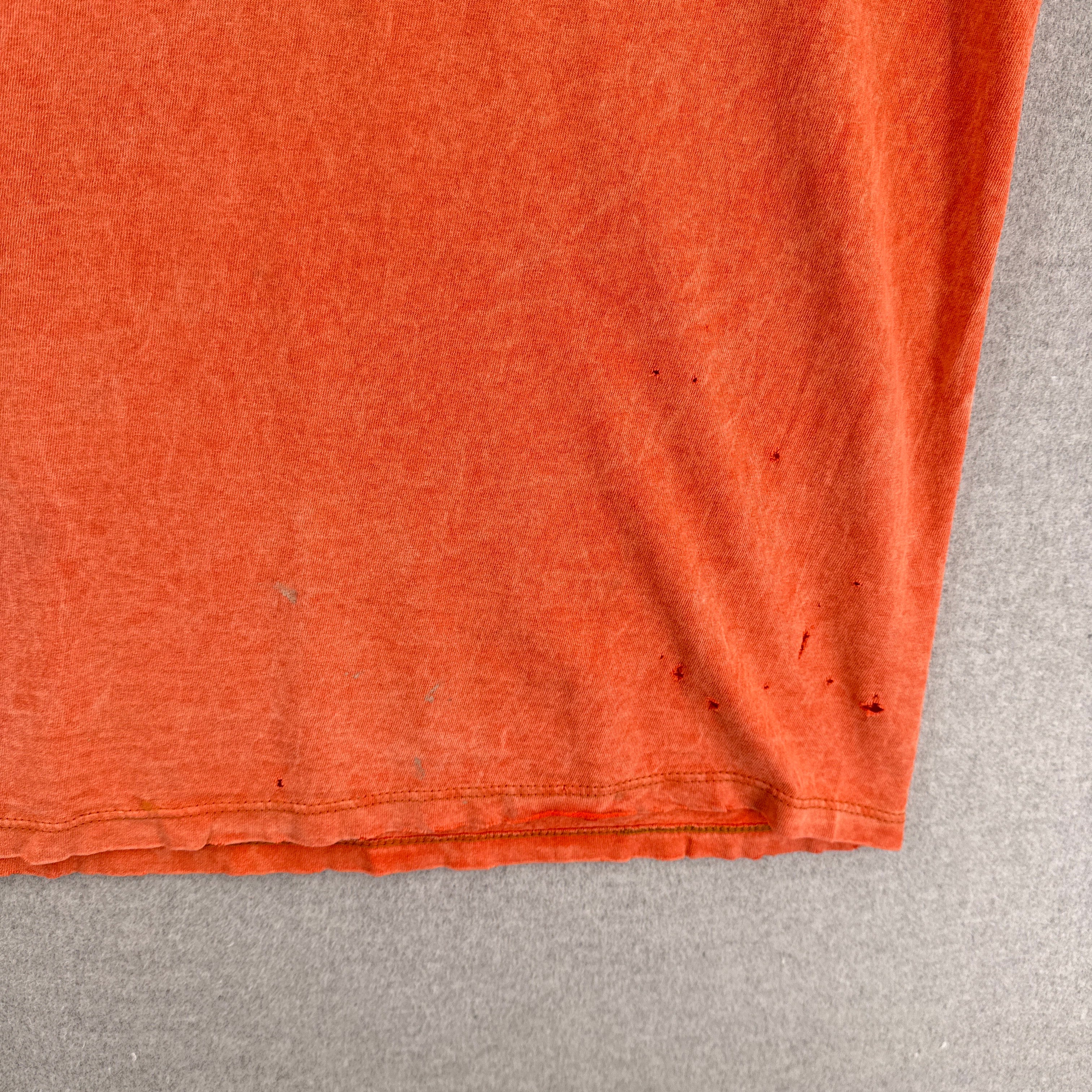 rips and holes at the bottom of the shirt