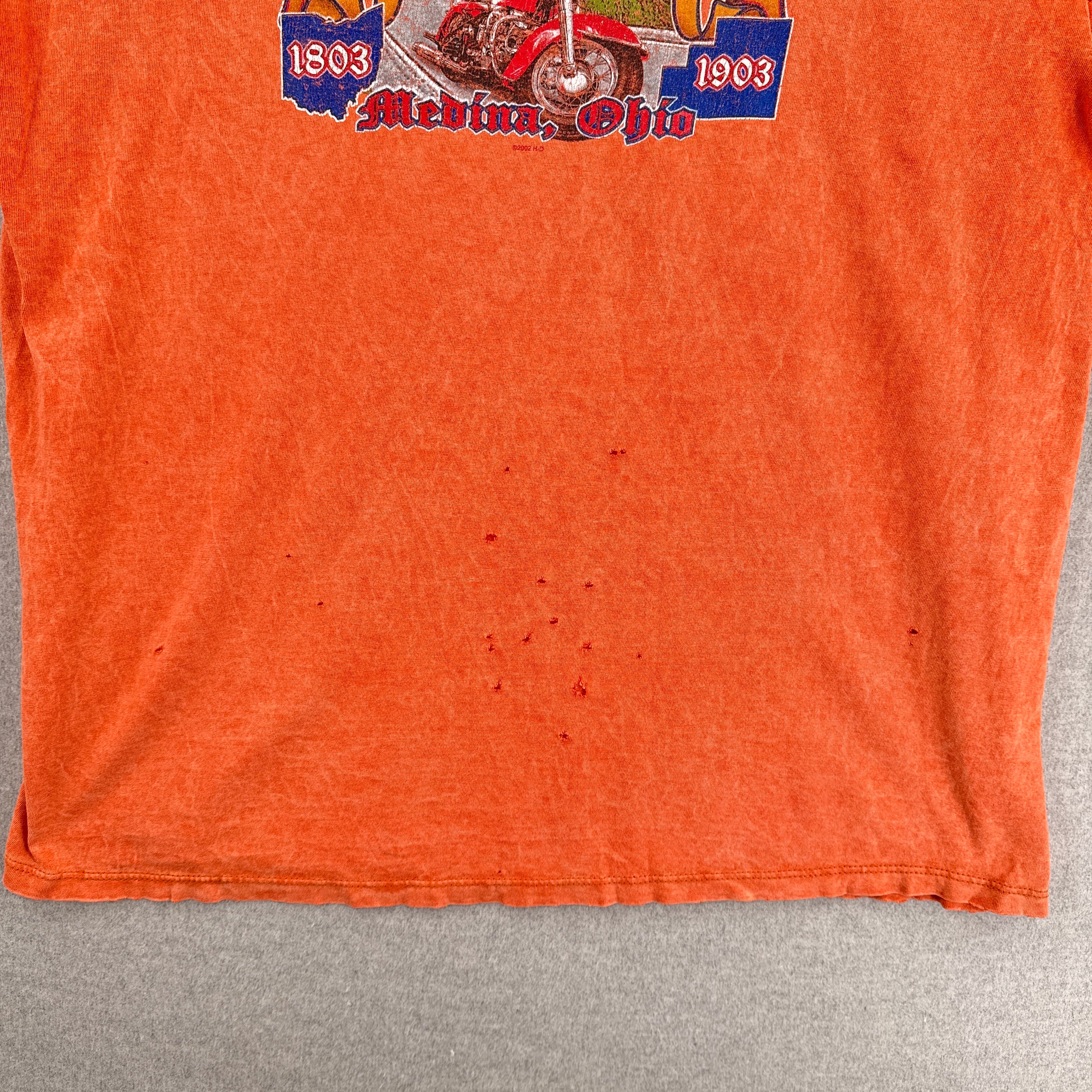 back of shirt shows many small holes