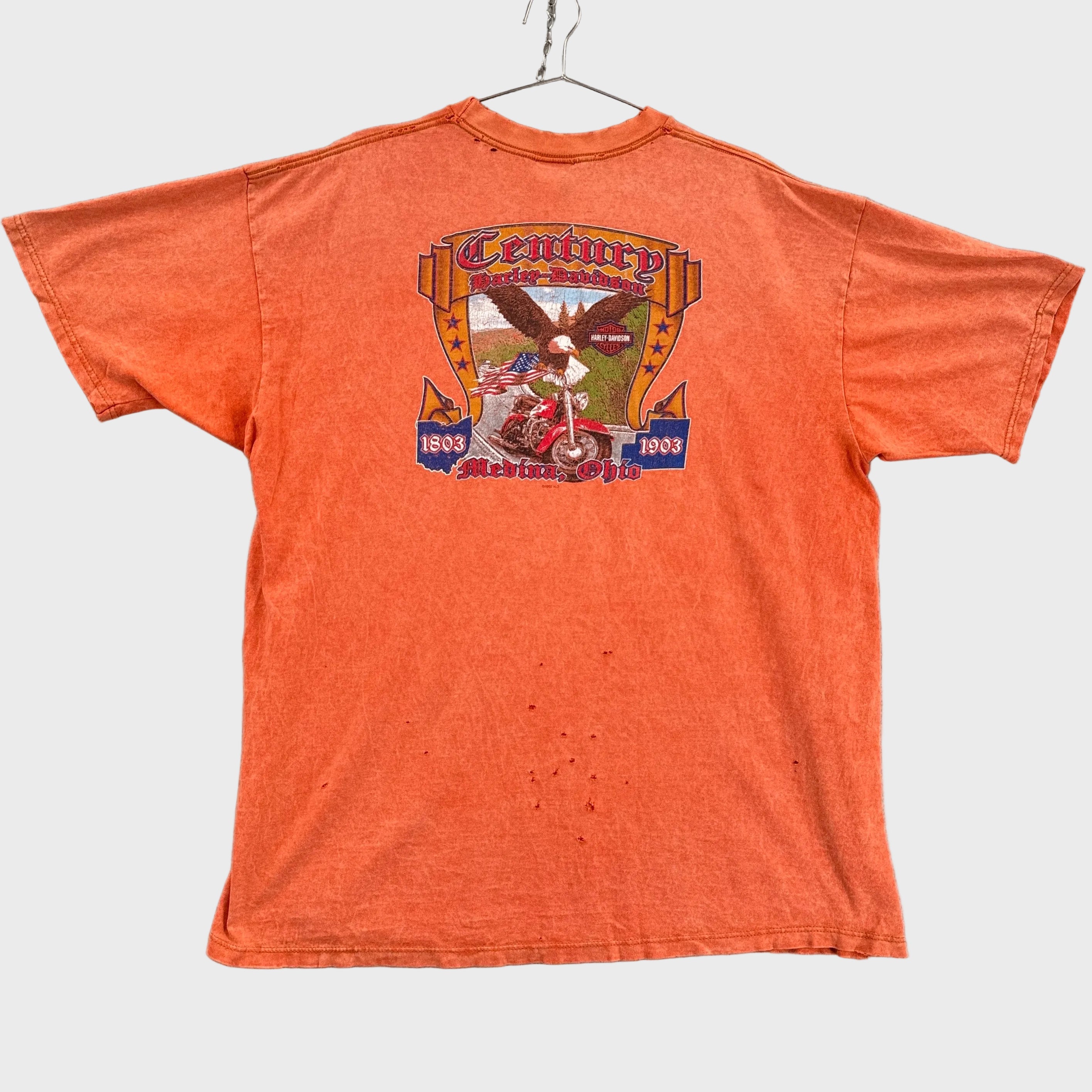 Orange t-shirt with graphic design on a gray background