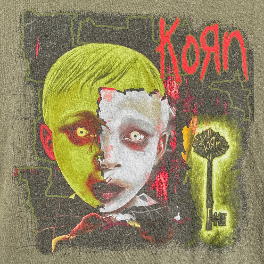 T-shirt with a graphic design featuring a face split into green and white halves, with 'Korn' branding.