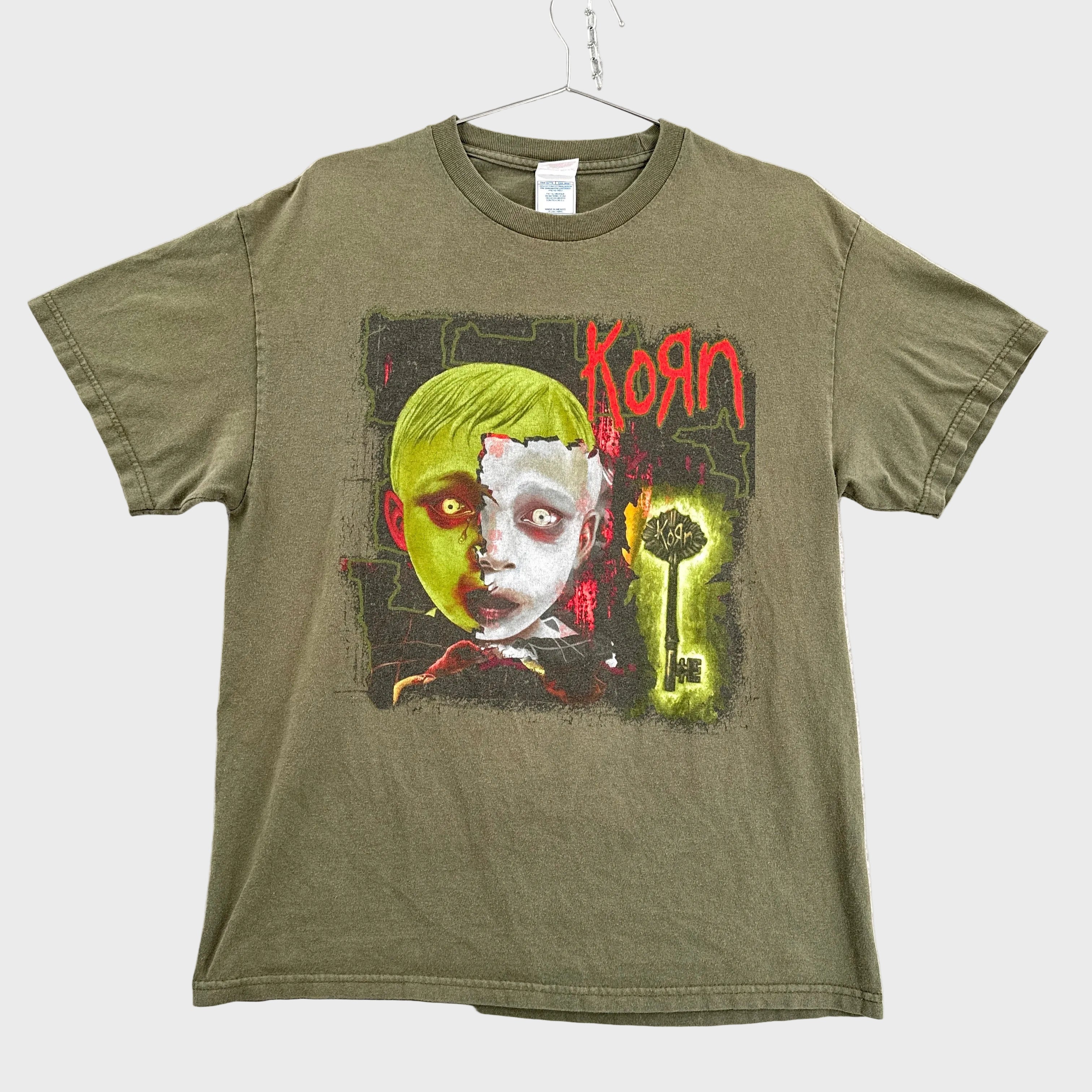 Green t-shirt with Korn graphic design on a textured white background