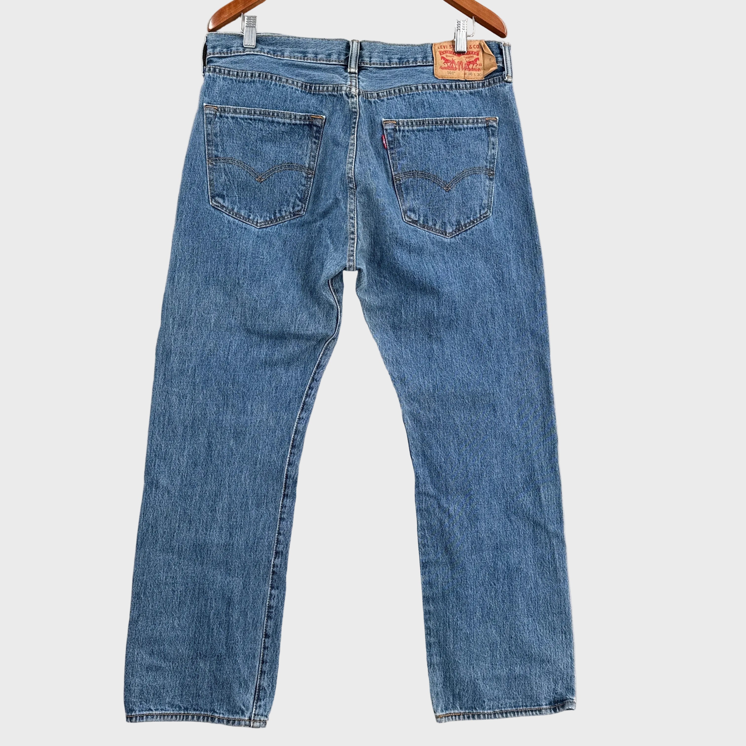 Pair of blue jeans laid flat on a gray surface