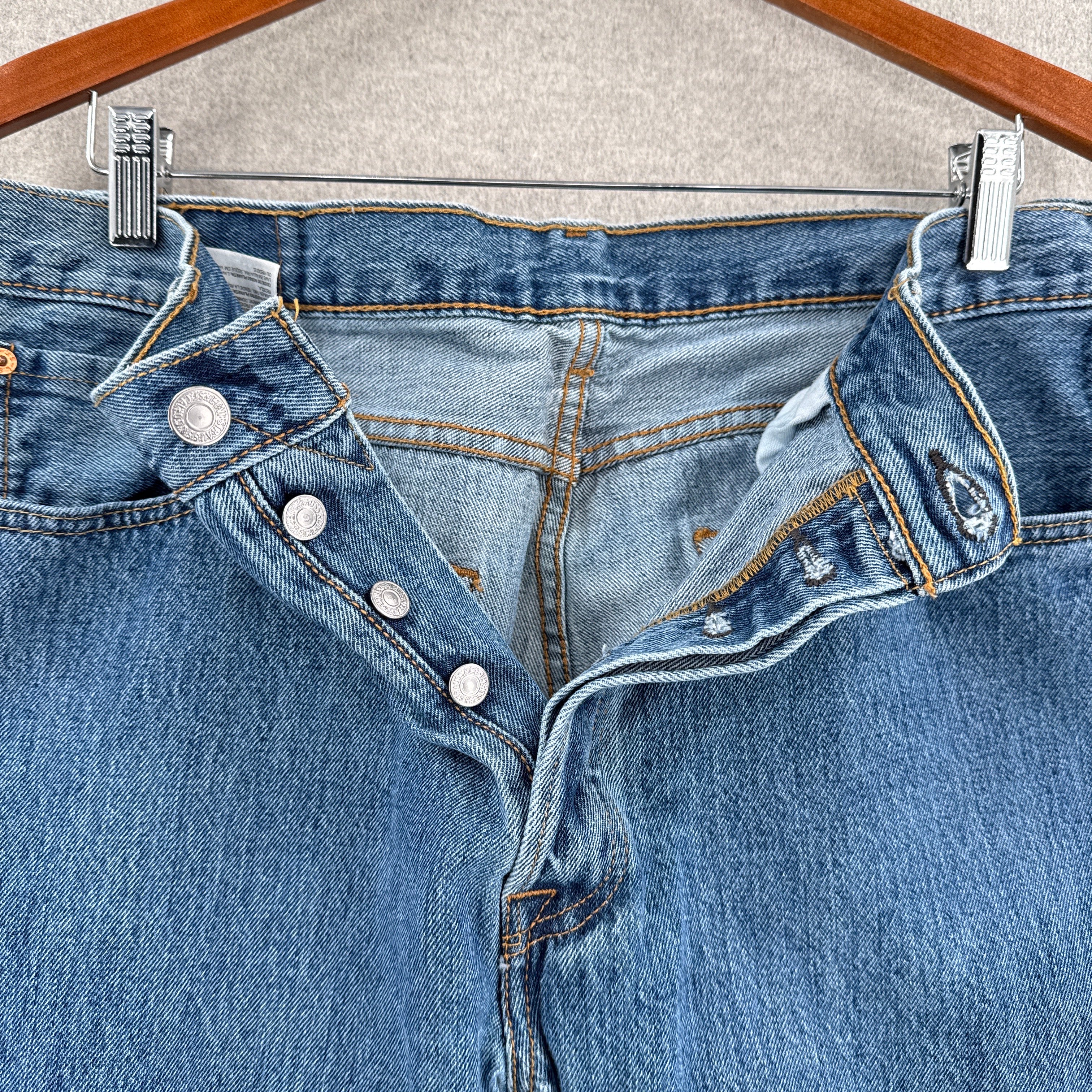 Close-up of a blue denim pants with buttons on a neutral background