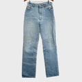 Pair of light blue jeans on a gray surface