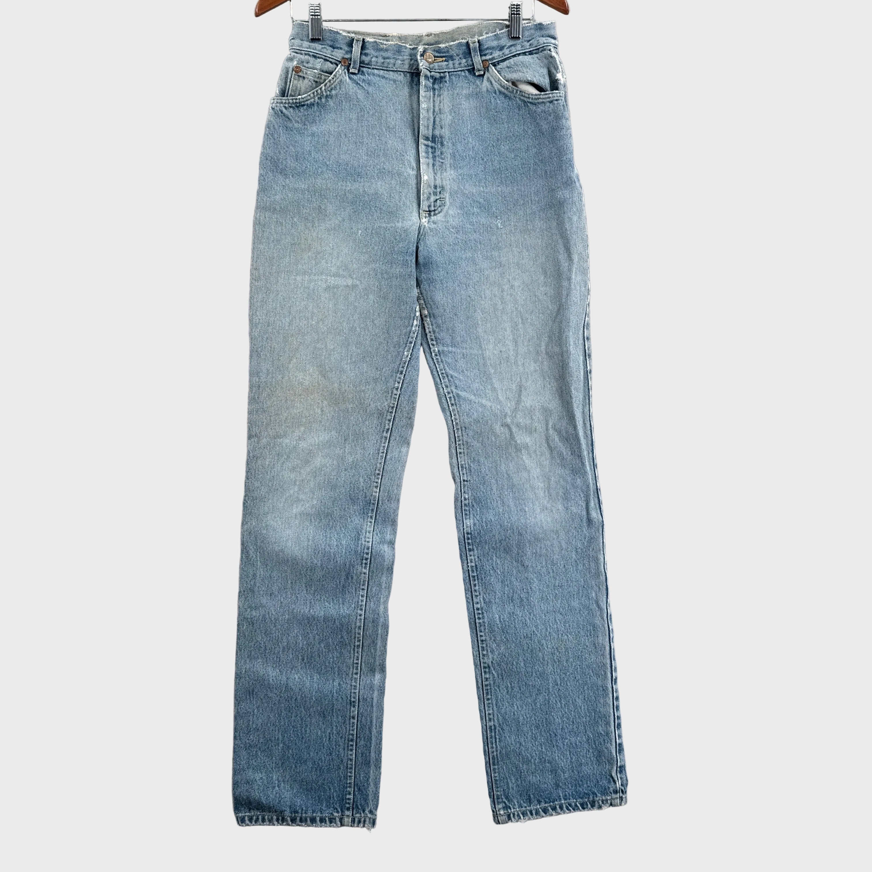 Pair of light blue jeans on a gray surface