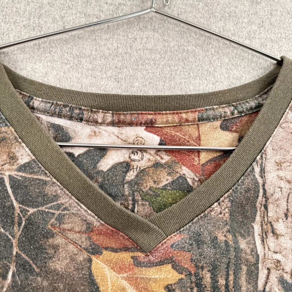 Close-up of a camouflage-patterned shirt with green trim on a hanger.