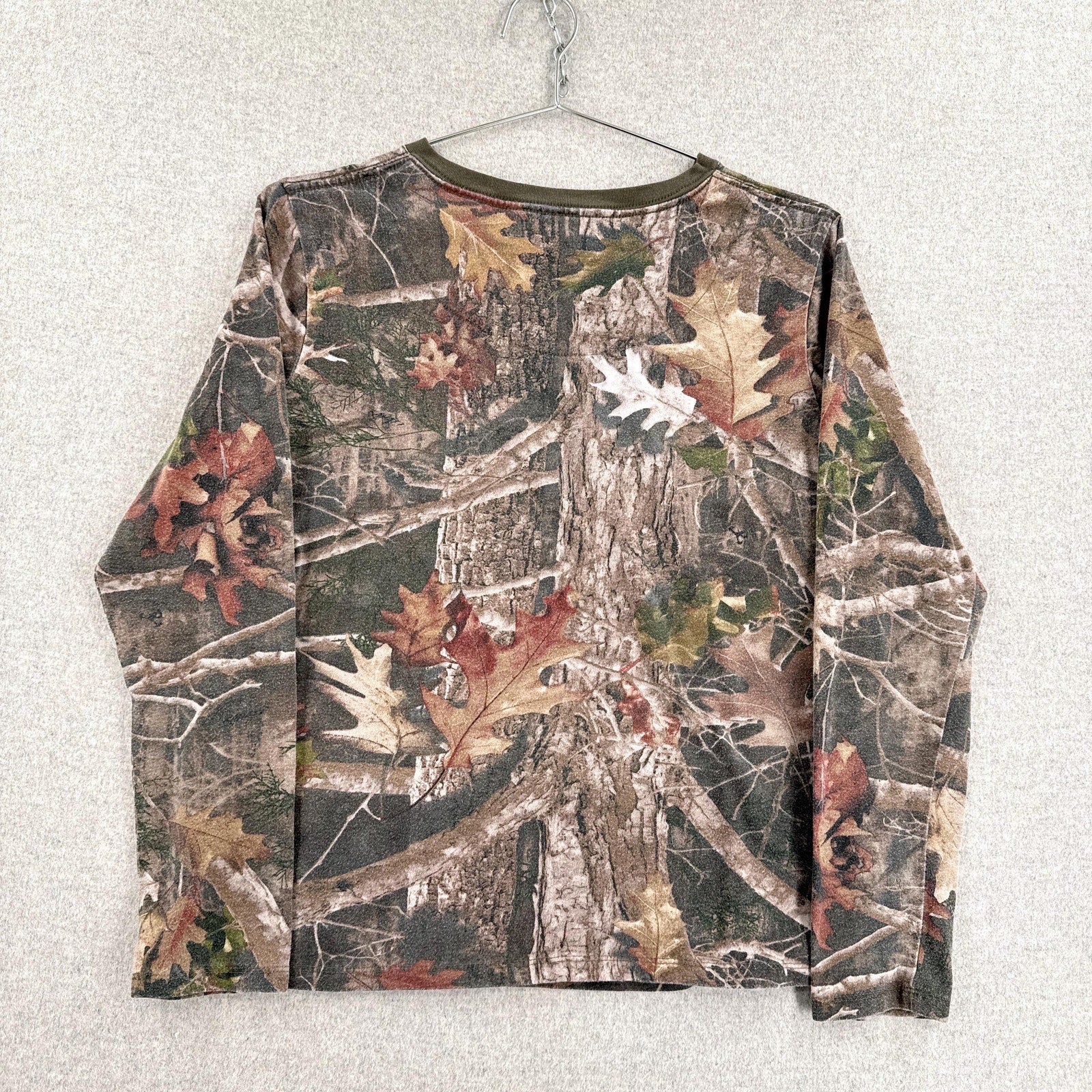 Camouflage-patterned shirt on a hanger against a light gray background