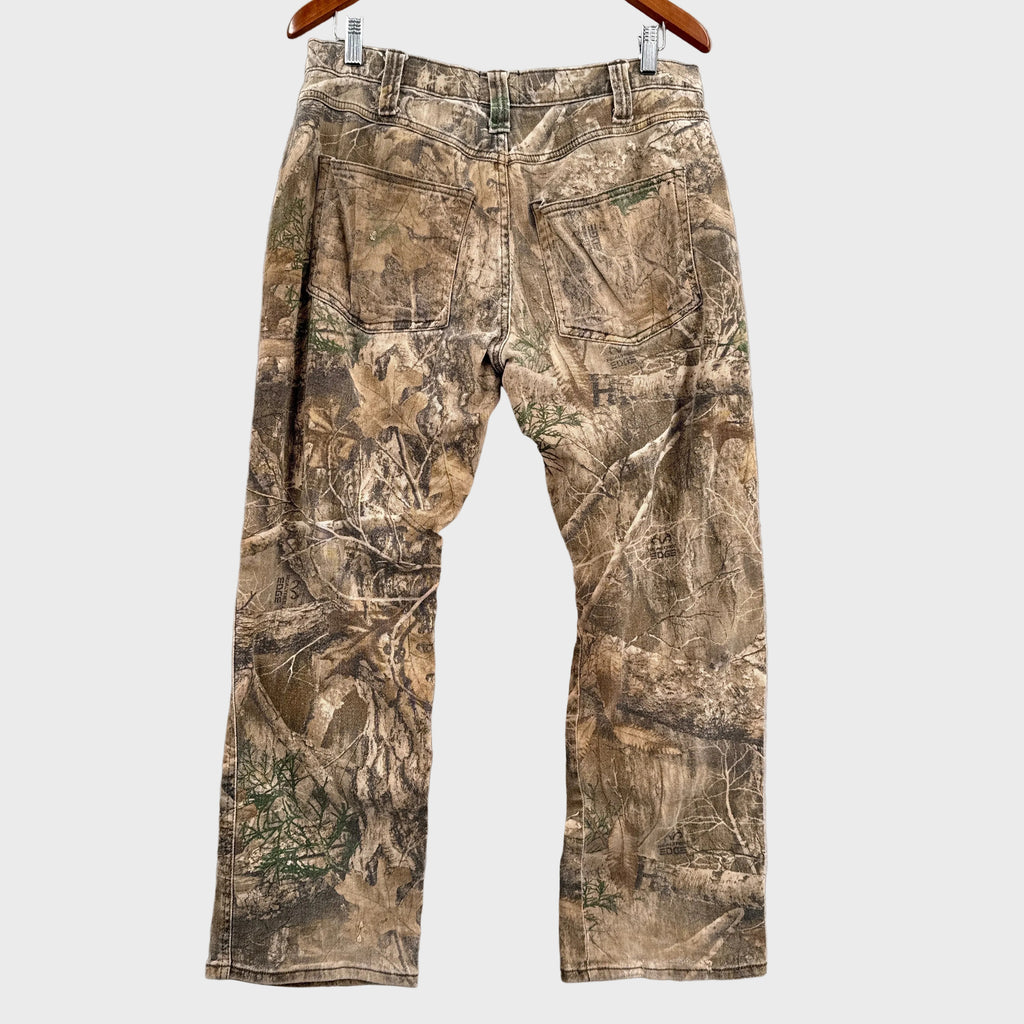 Camouflage pants laid flat on a gray surface