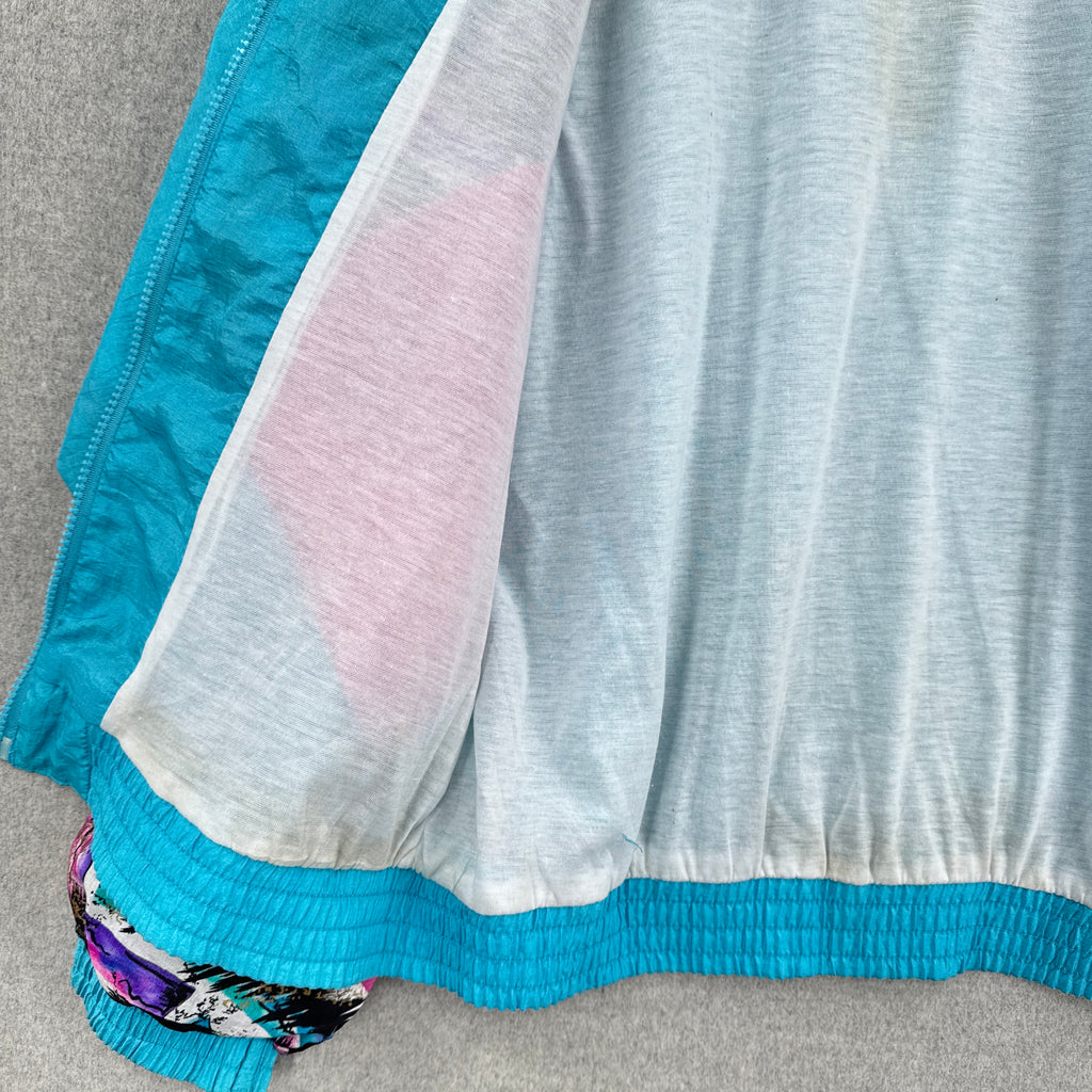 Close-up of a inside fabric with blue, gray, and pink colors on a gray surface. slight discolouration