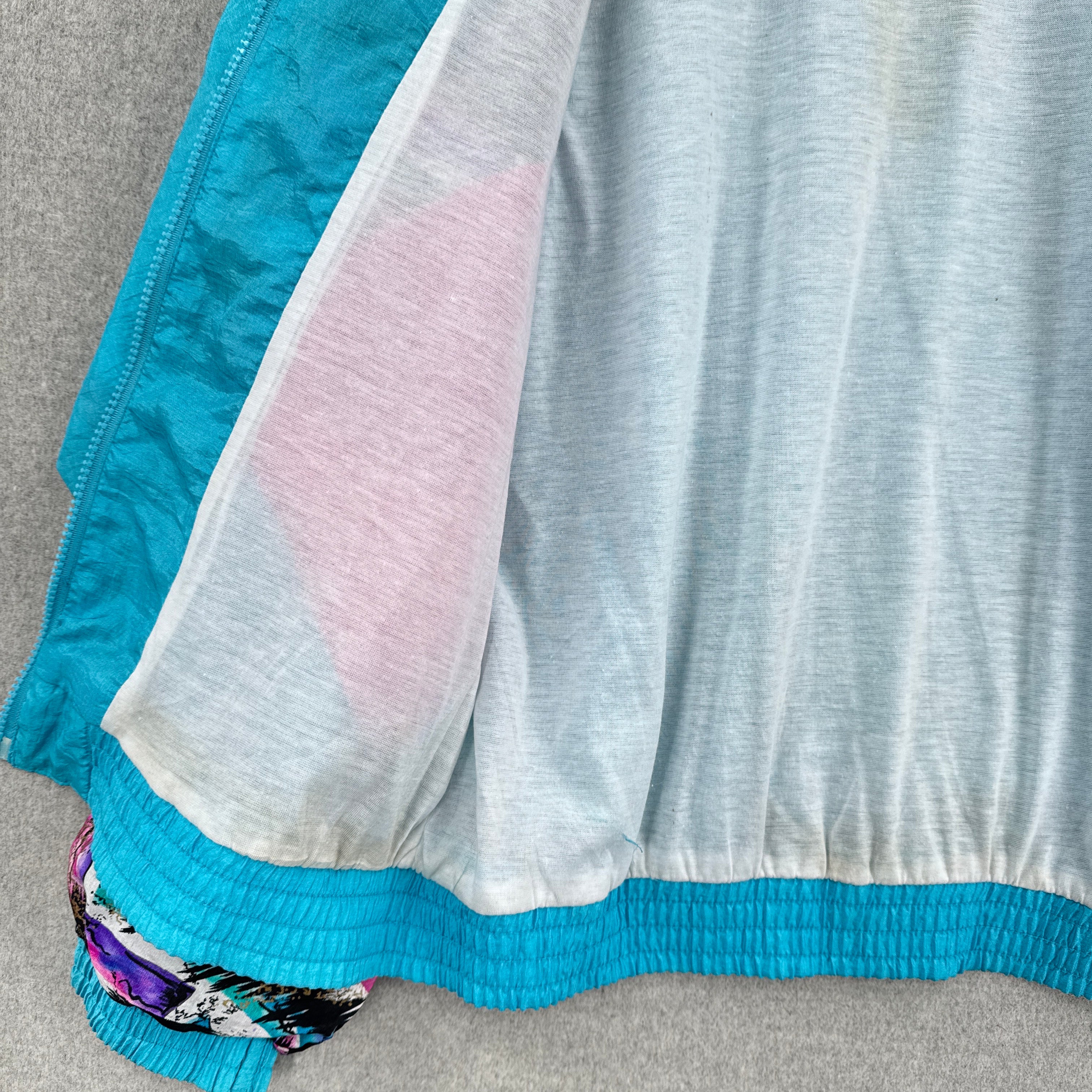 Close-up of a inside fabric with blue, gray, and pink colors on a gray surface. slight discolouration