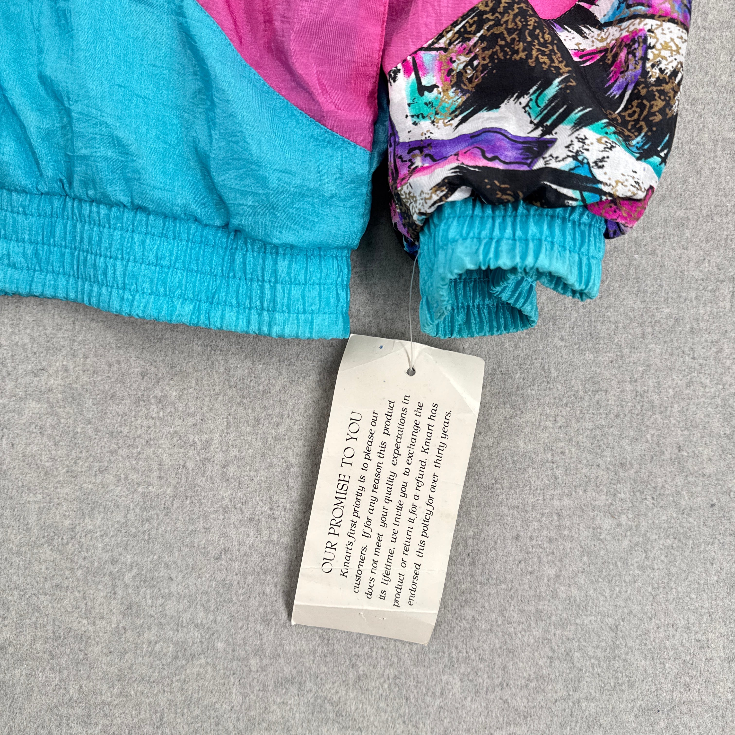 Colorful jacket with a tag on a gray surface