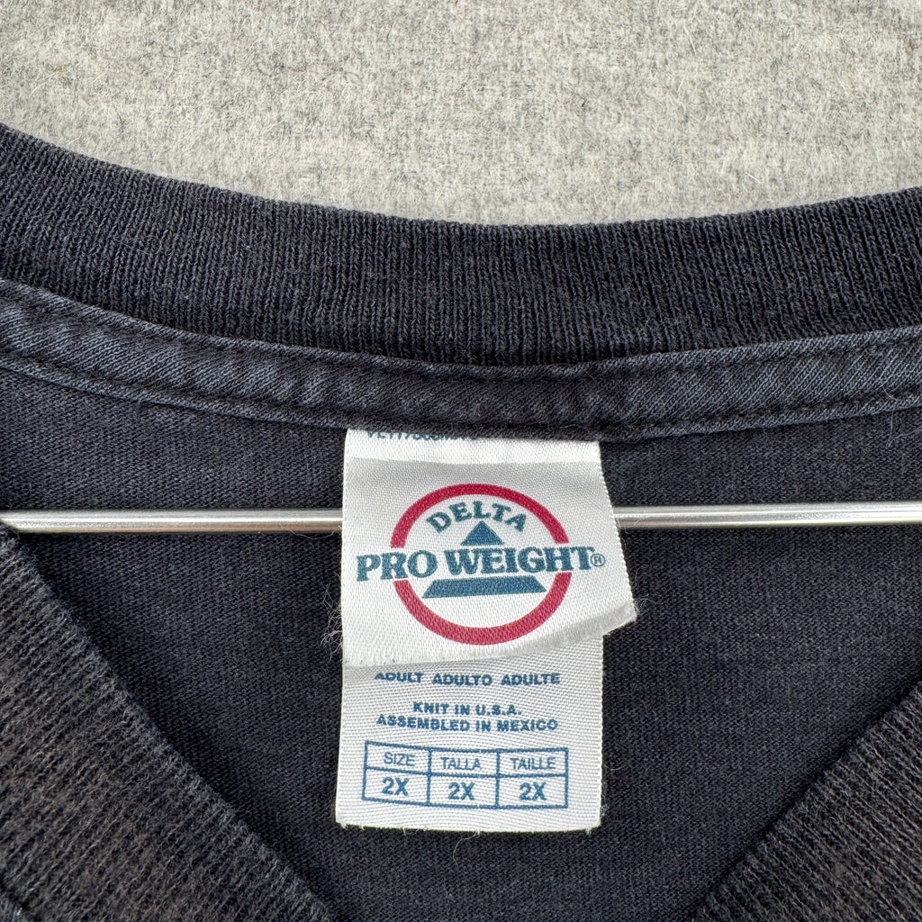 Close-up of a Delta Pro Weight label on a dark fabric background. size 2XL