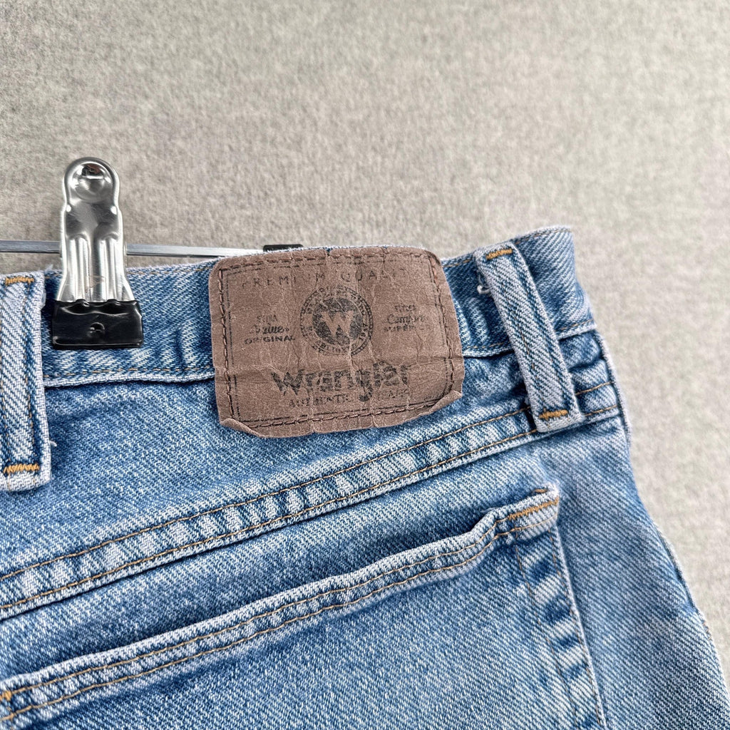 Close-up of Wrangler jeans with a label on a textured surface