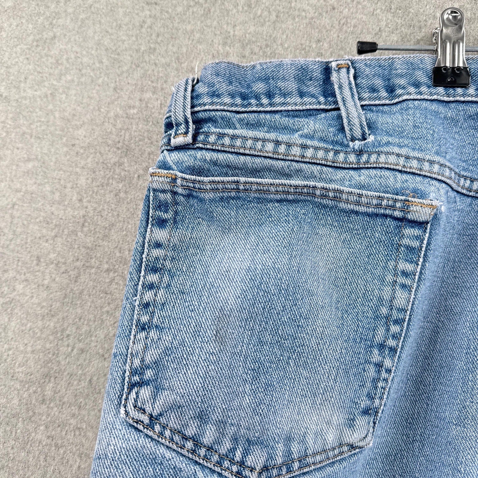 Close-up of a blue denim pocket with a gray background