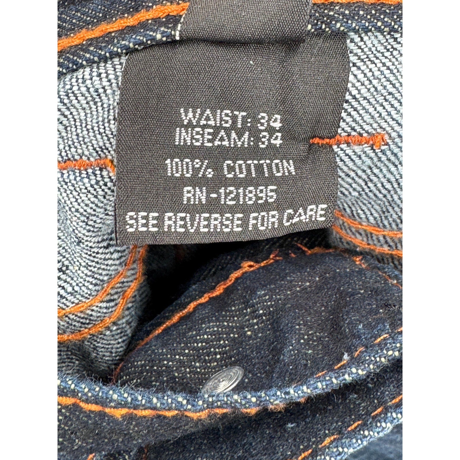 Close-up of a denim label with size and material information. waist 34" inseam 34" 100% cotton