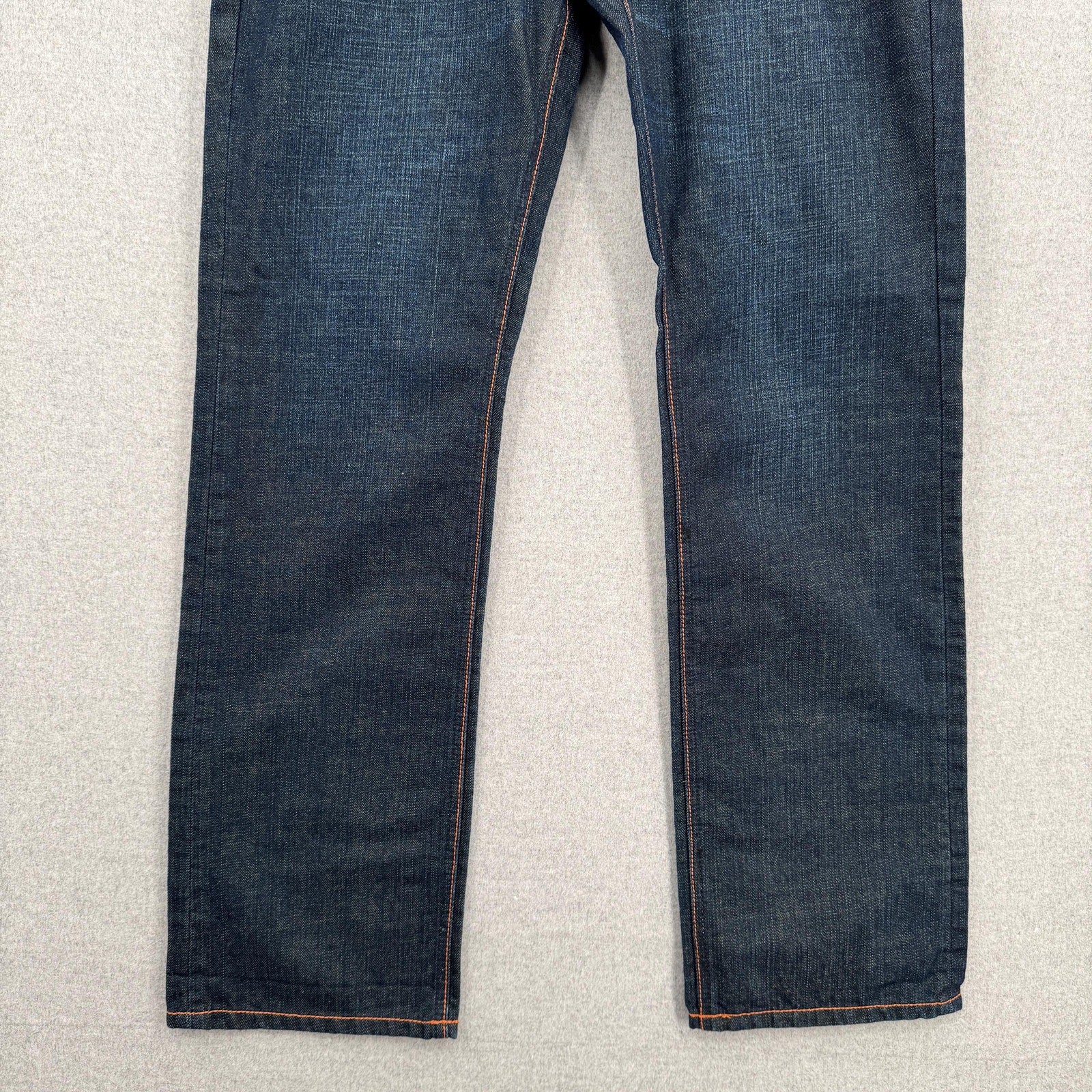 Pair of blue jeans on a light gray surface