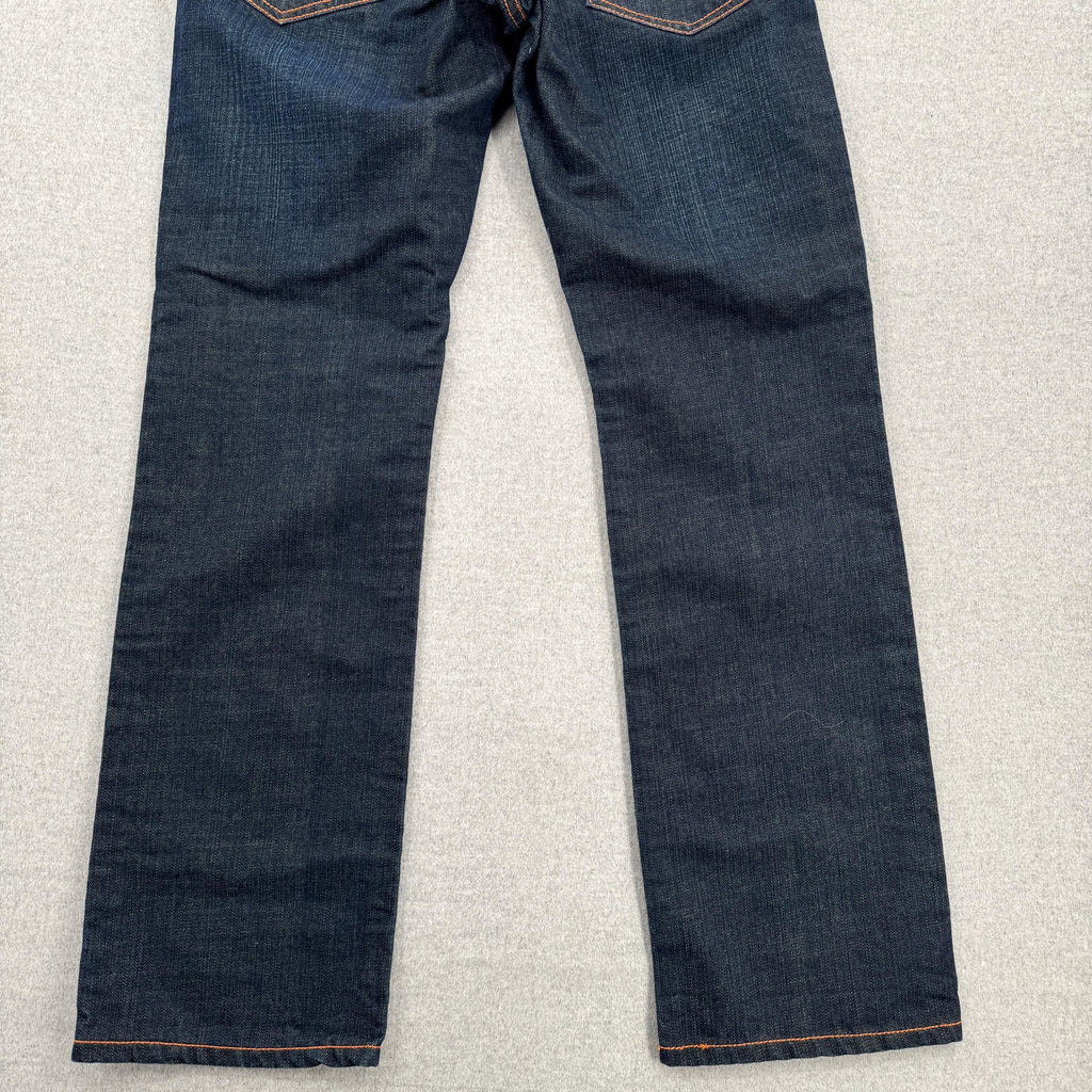 Pair of dark blue jeans on a light gray surface