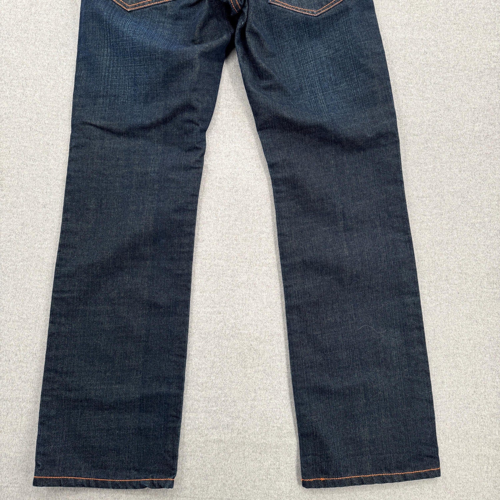 Pair of dark blue jeans on a light gray surface