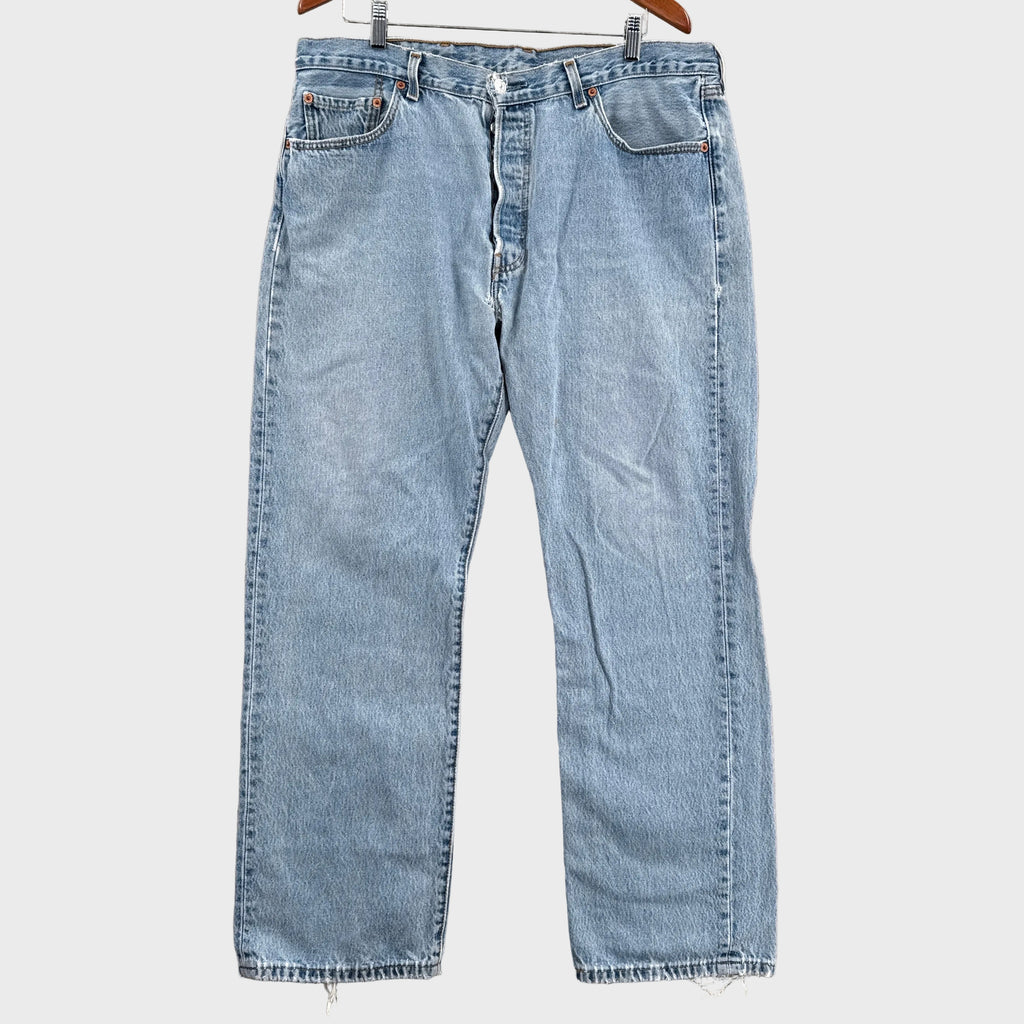 Pair of light blue jeans on a gray surface