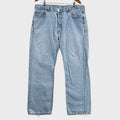 Pair of light blue jeans on a gray surface