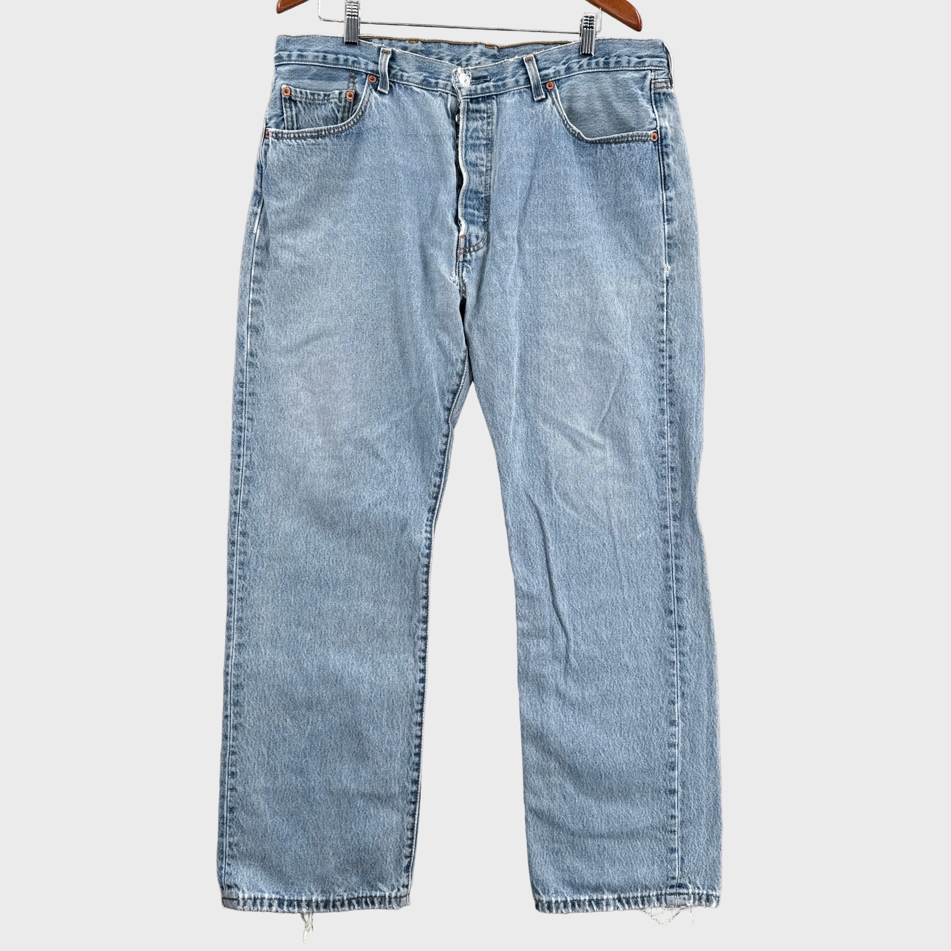 Pair of light blue jeans on a gray surface