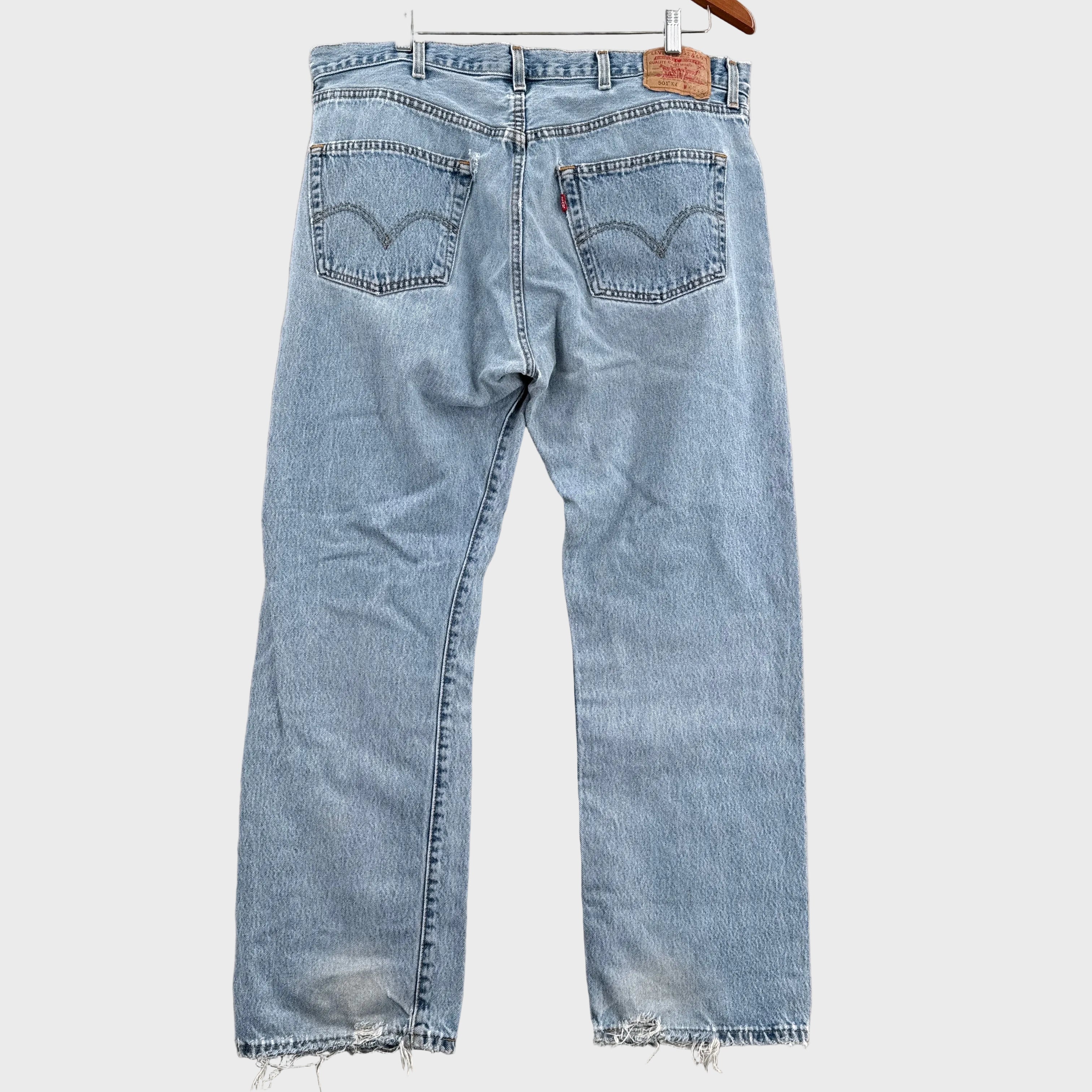 Light blue jeans with frayed hems on a gray surface