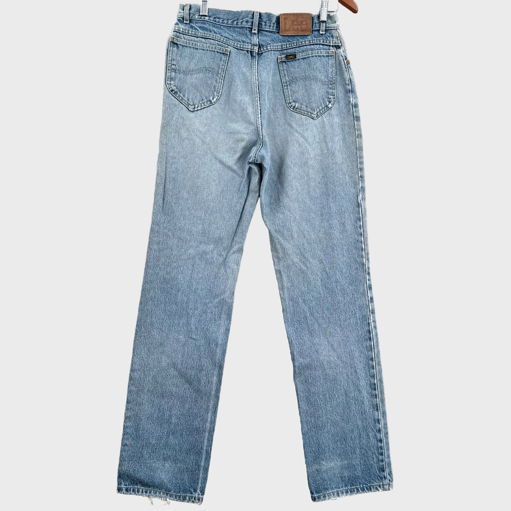 Pair of light blue jeans on a gray surface