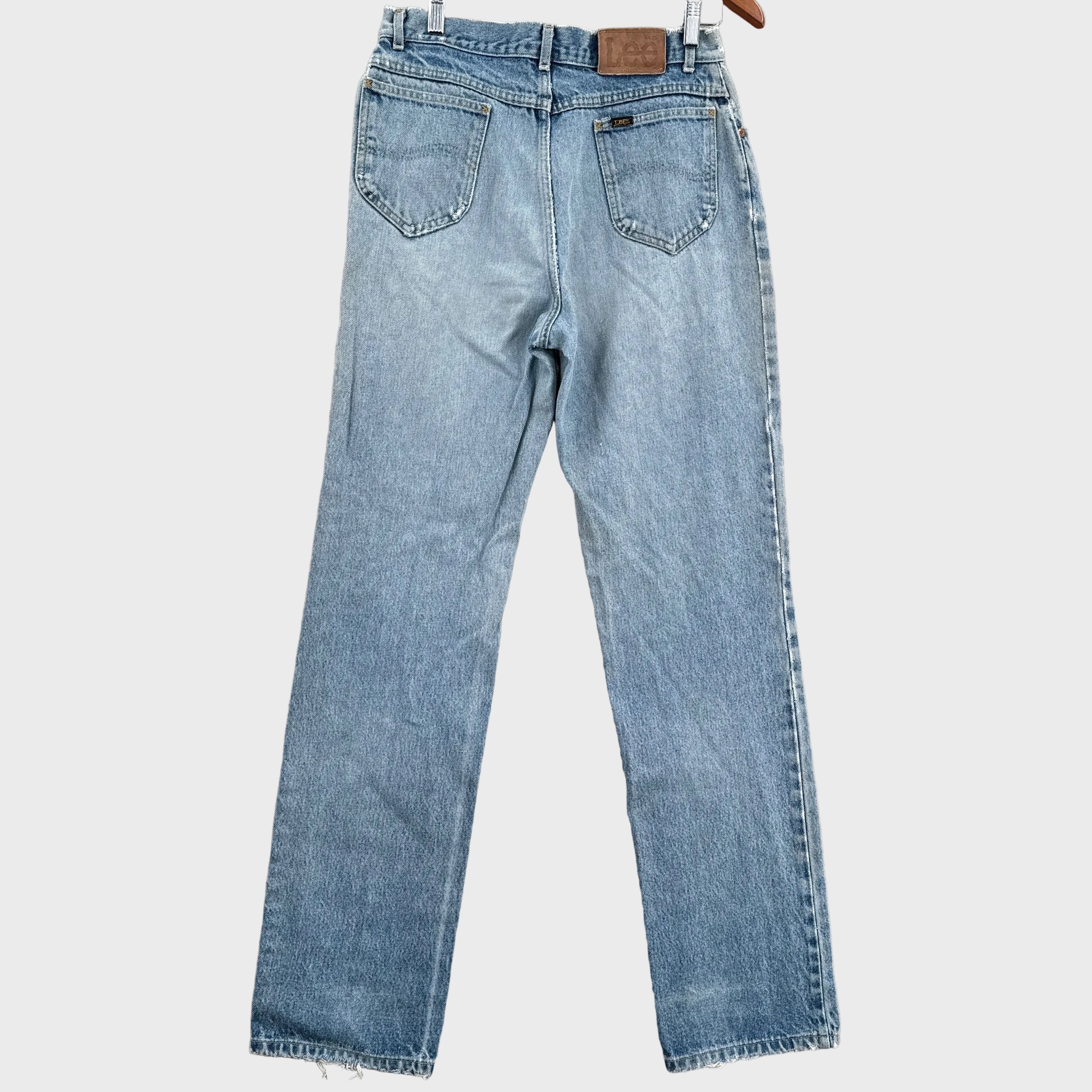 Pair of light blue jeans on a gray surface